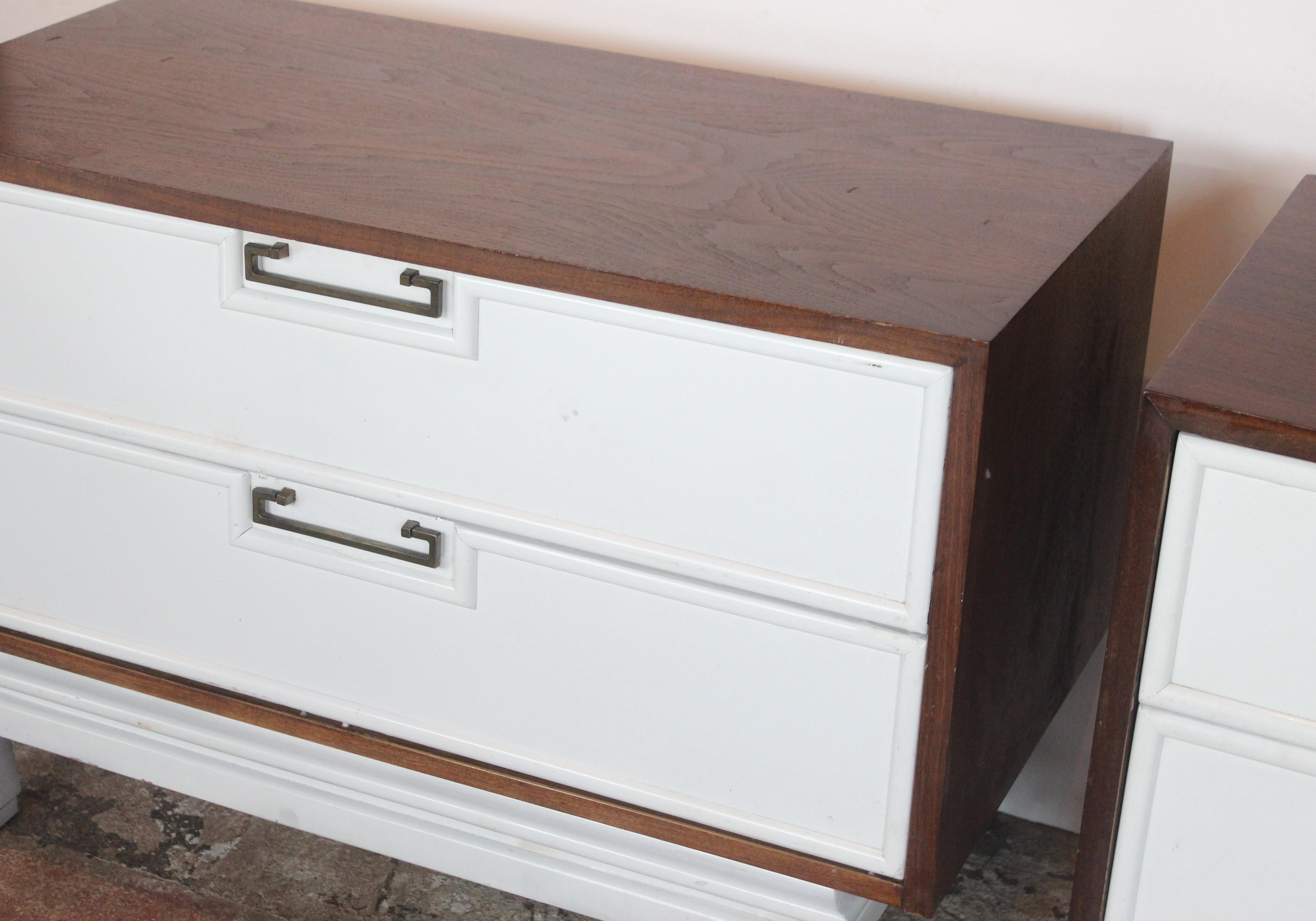 Mid-century Asian-inspired nightstand. The white drawers are framed in beautiful light mahogany wood standing on a white finish base and antiqued brass hardware by American of Martinsville. Maker's mark inside drawer.