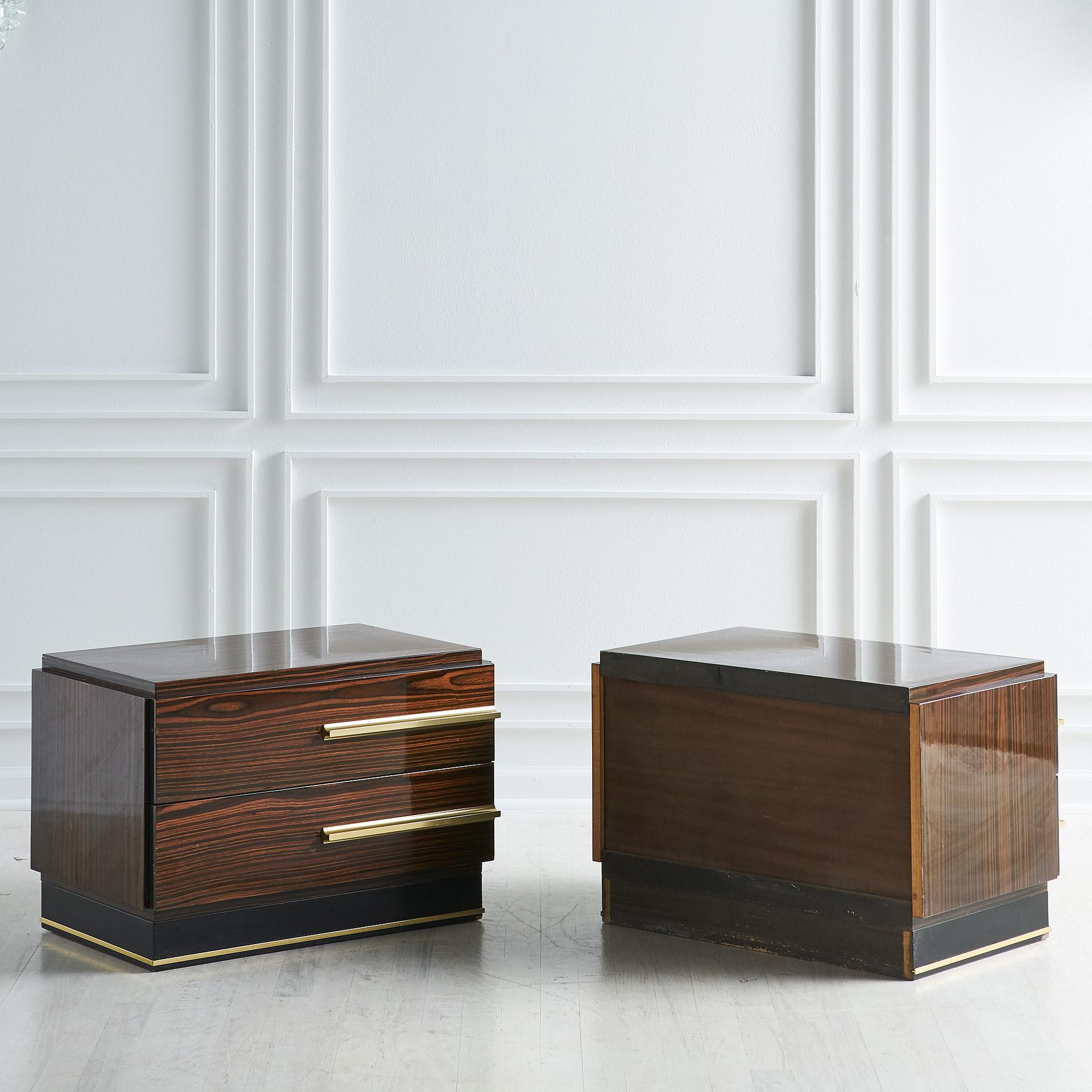 A pair of modern, low nightstands by Italian designer, artist, and musician Luciano Frigerio, (1928-1999). Featuring a rosewood veneer, long brass finish handles, and a plinth base.