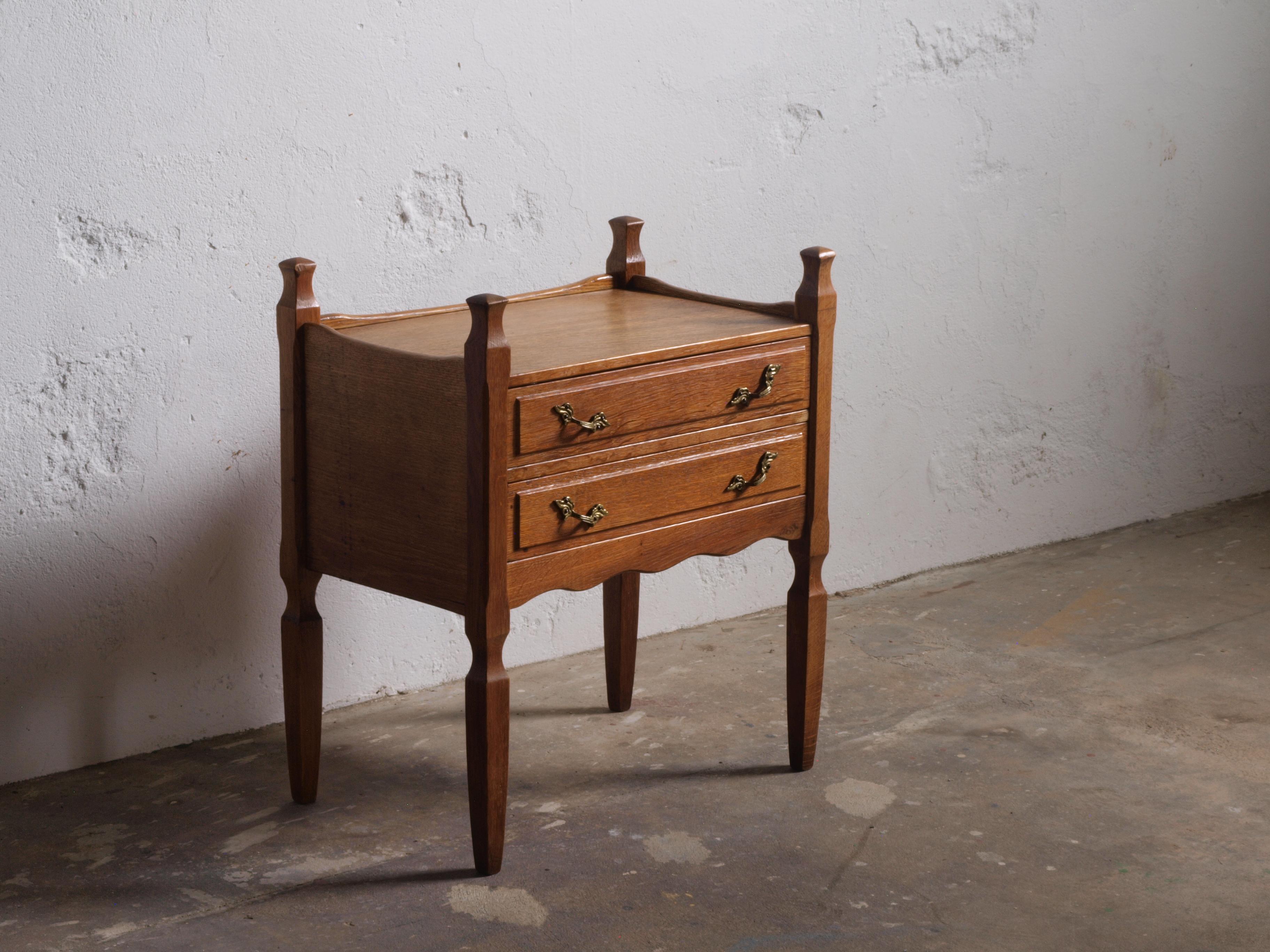 Presenting a pair of oak bedside tables by Henning Kjærnulf, crafted in the 1960s by Nyrup Møbelfabrik. In good vintage condition, these nightstands exhibit a poetic blend of baroque and modern design, reflecting the duality of life. Notably, they