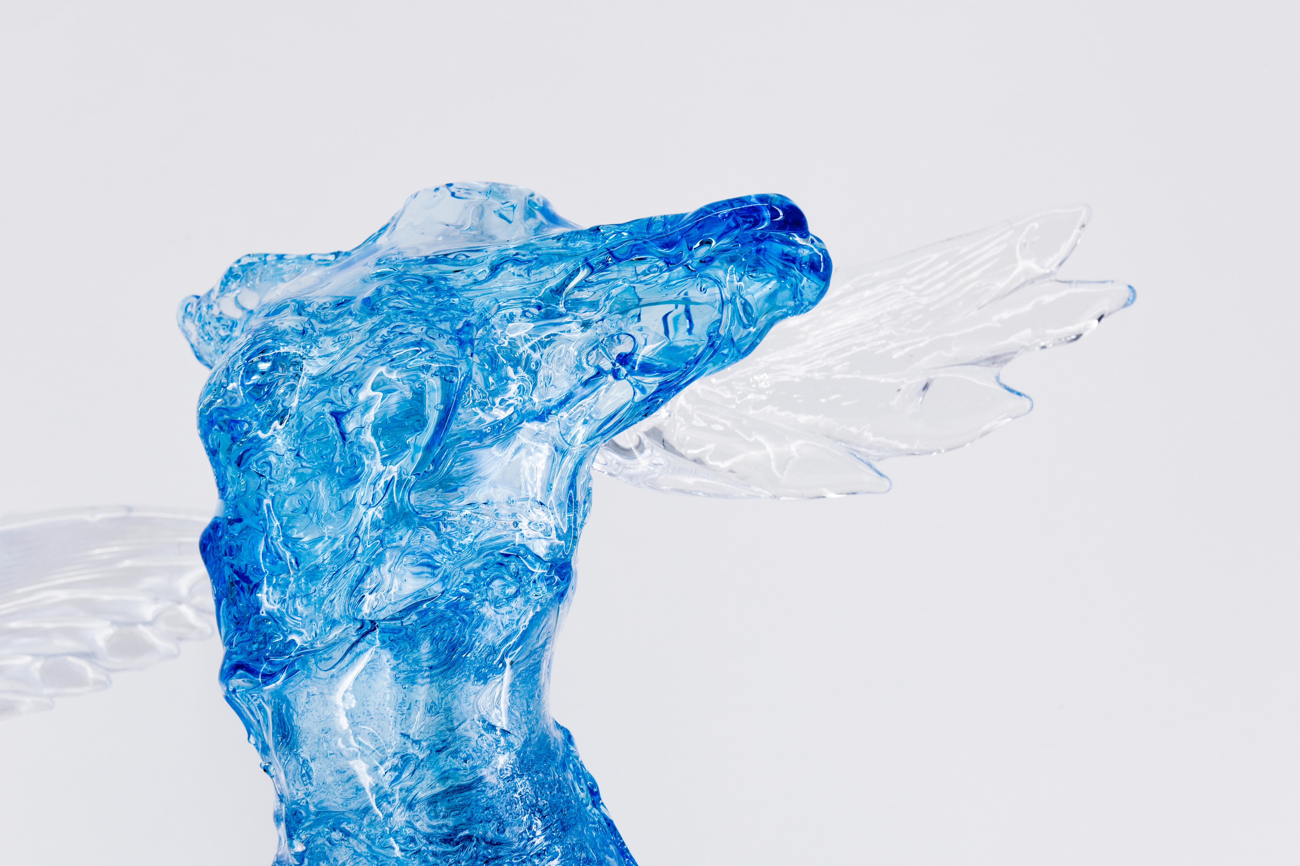 Un omaggio a uno dei simboli della cultura ellenica, ispirato alla famosa scultura Nike di Samotracia esposta al Louvre di Parigi. La figura della donna alata è avvolta in un tessuto leggero che scorre nel vento e aderisce al corpo della giovane