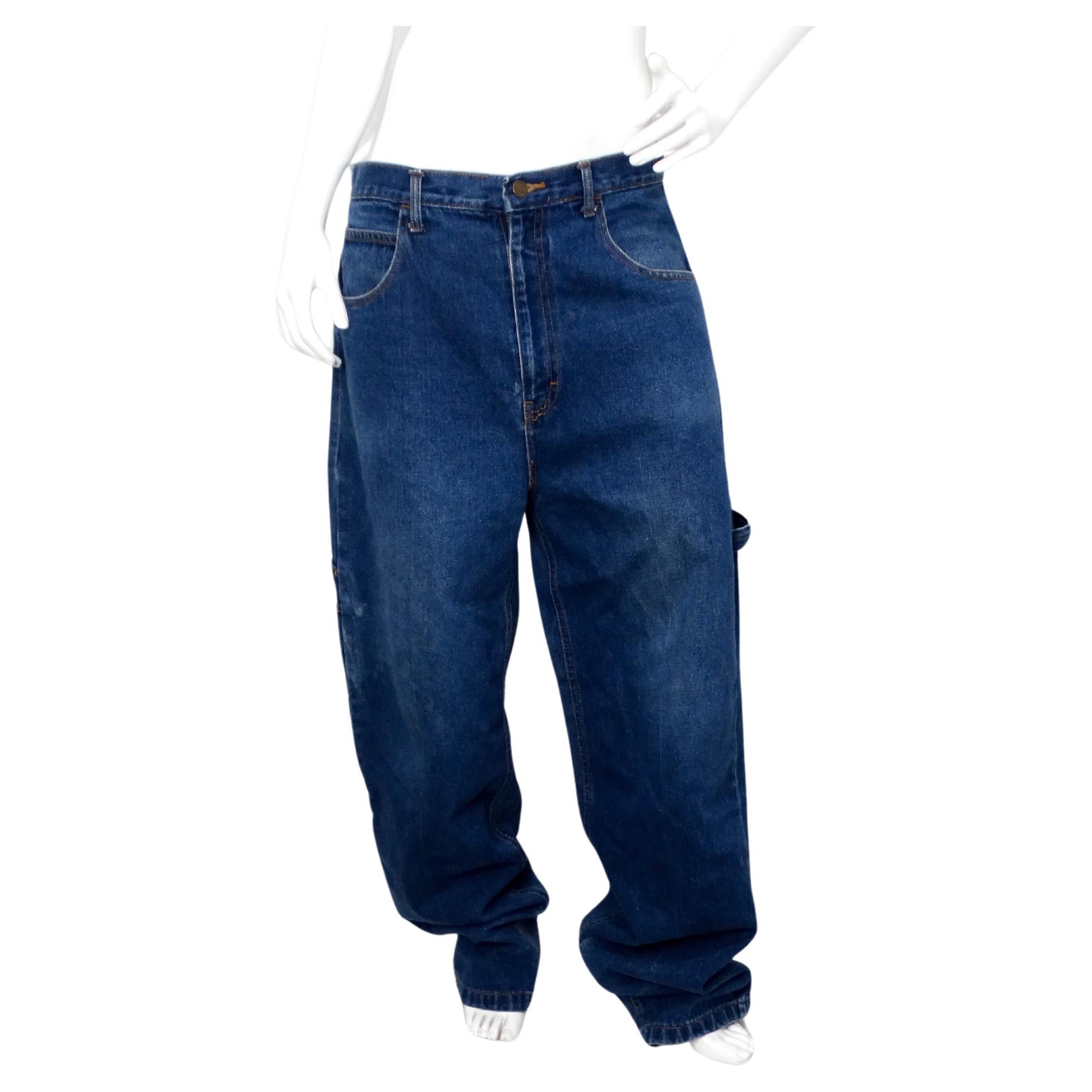 Retrocede a la época icónica de los 90 con estos vaqueros Baggy estilo carpintero en denim azul con costuras Nike USA. Conocidos por su corte holgado y relajado, estos vaqueros ofrecen una comodidad inigualable y un auténtico aire de los 90. El