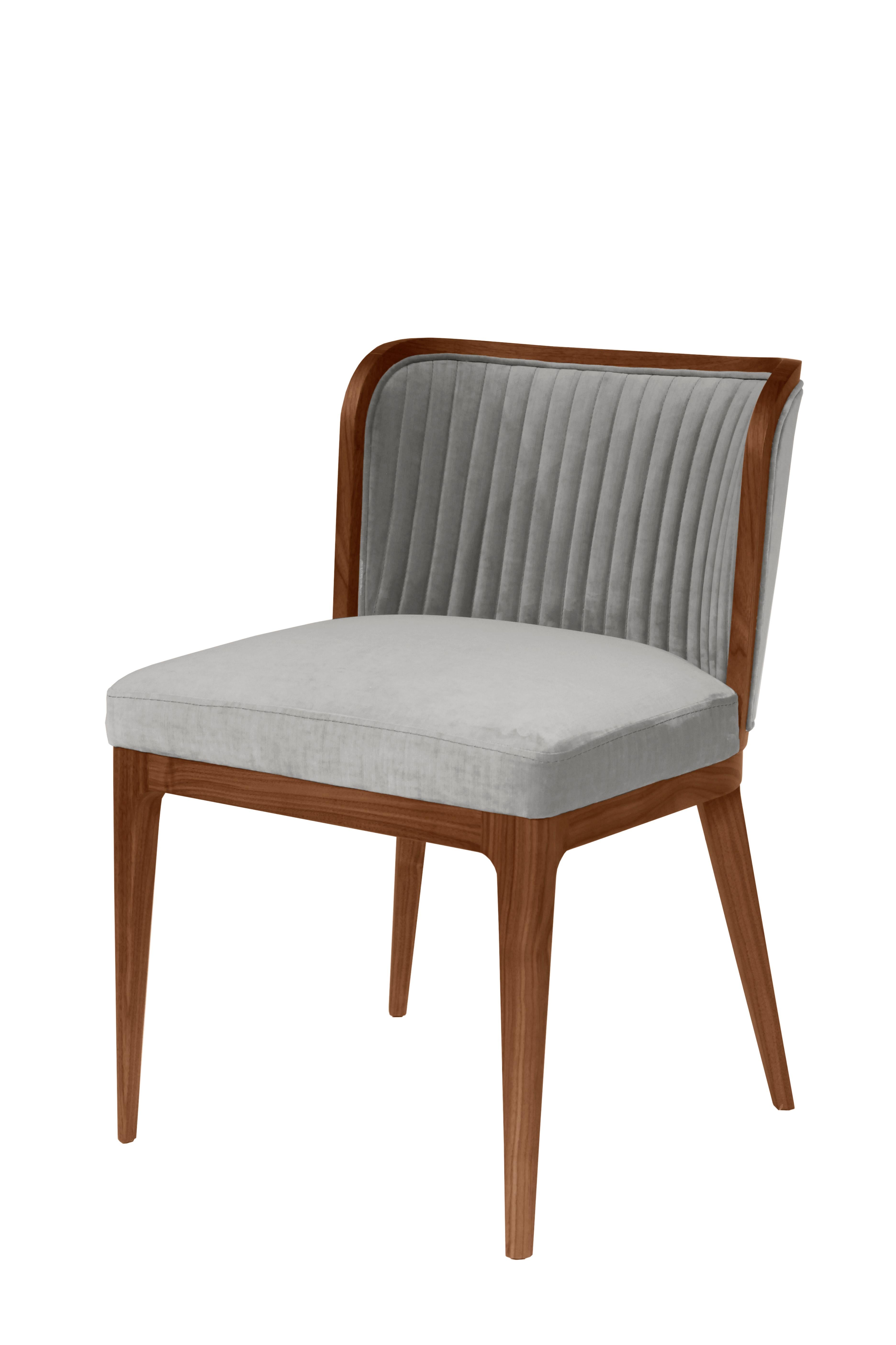 A low and wide rounded back with channel tufting and a deep cushioned seat offers an inviting chair for any dinner setting. Flared back legs provide an elegant touch to a Classic silhouette.