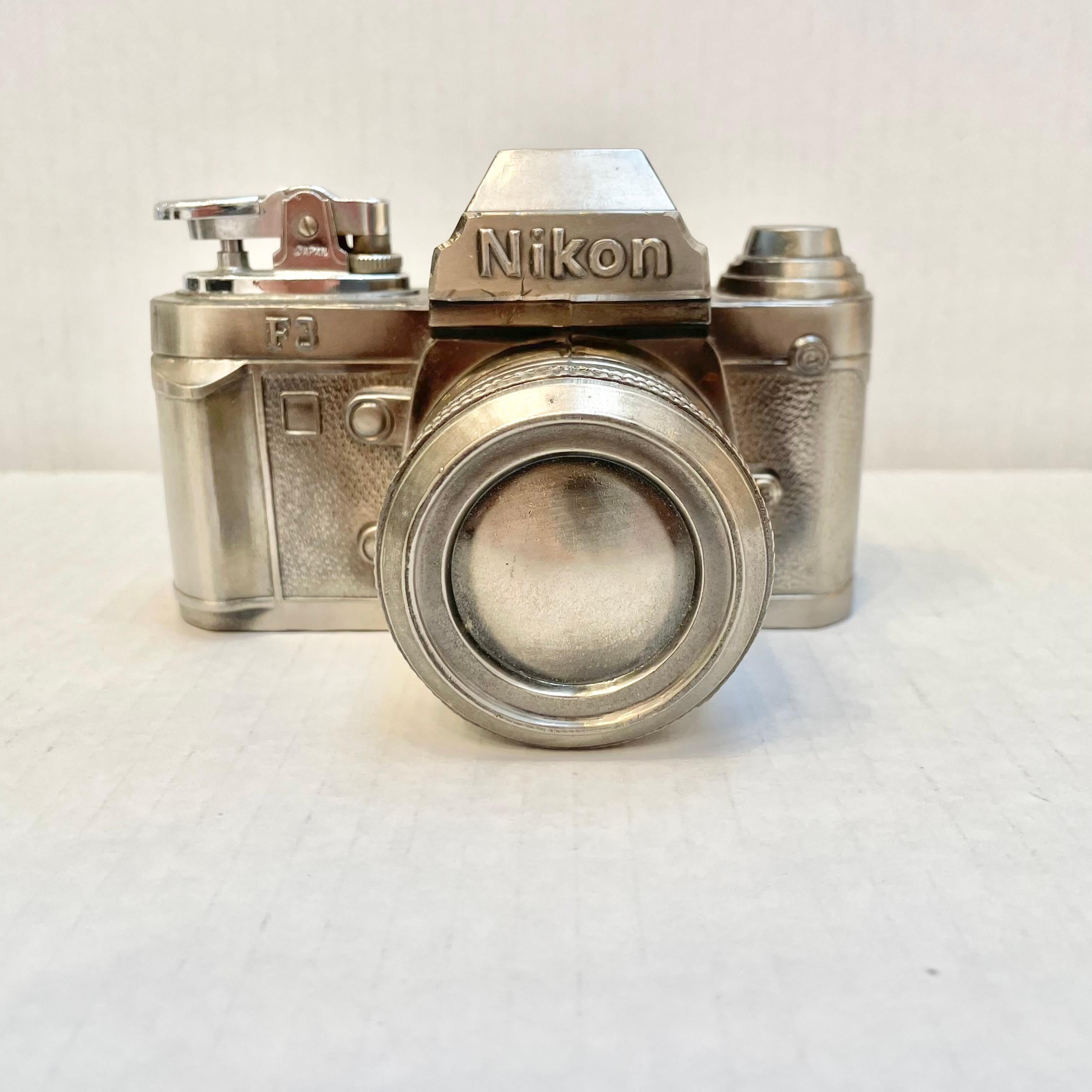 Cool vintage table lighter in the shape of a Nikon camera. Tons of detailing to metal camera. Made in Japan. Excellent condition. Comes with original box. Good working condition. Great object.


 
