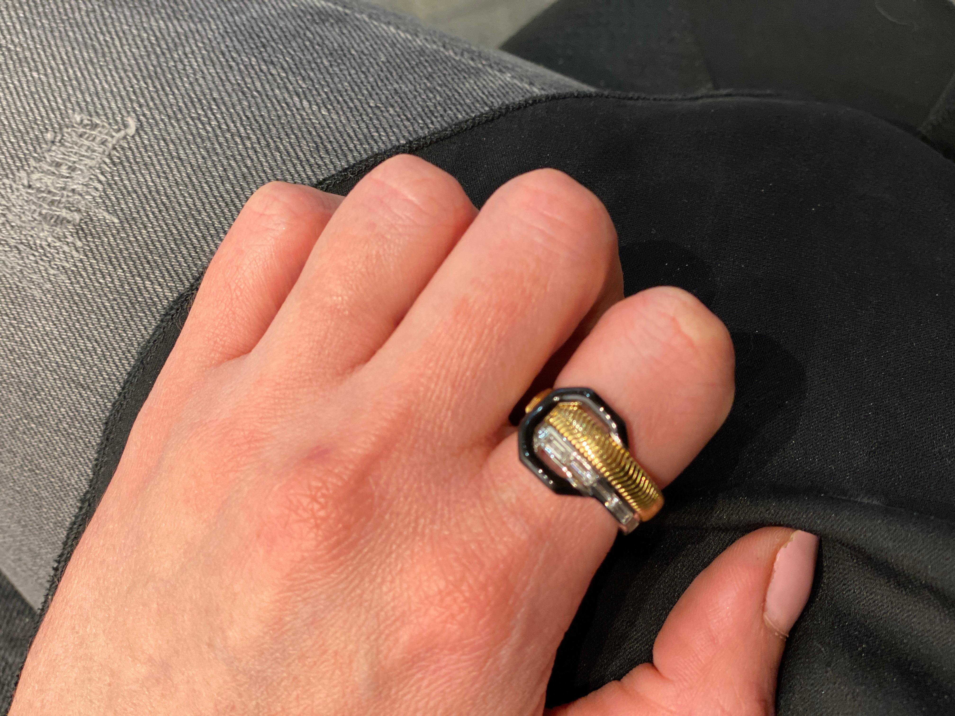Nikos Koulis creates stunning jewelry designs that are irresistible- exuding an effortlessly elegant style.

This ring features a baguette and trillion white diamonds and black enamel set in 18K yellow gold.

Details:
18K Yellow Gold
Trillion White