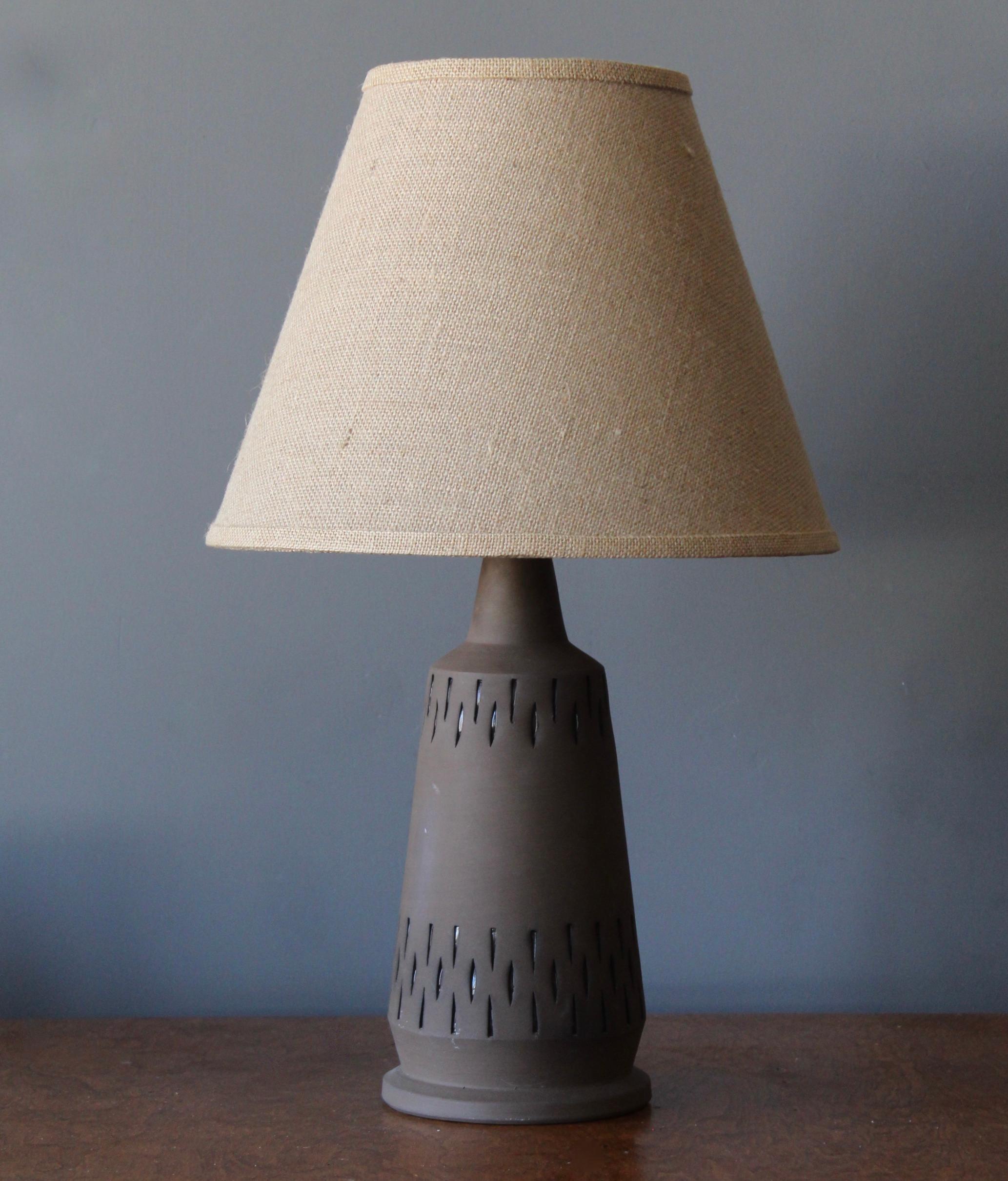 A table lamp, designed and produced by NILA, Alingsås Sweden, 1960s.

Handmade in stoneware. Stamped to underside. Features matte finish and simple incised ornamentation.

Stated dimensions exclude lampshade, height includes socket. Sold without