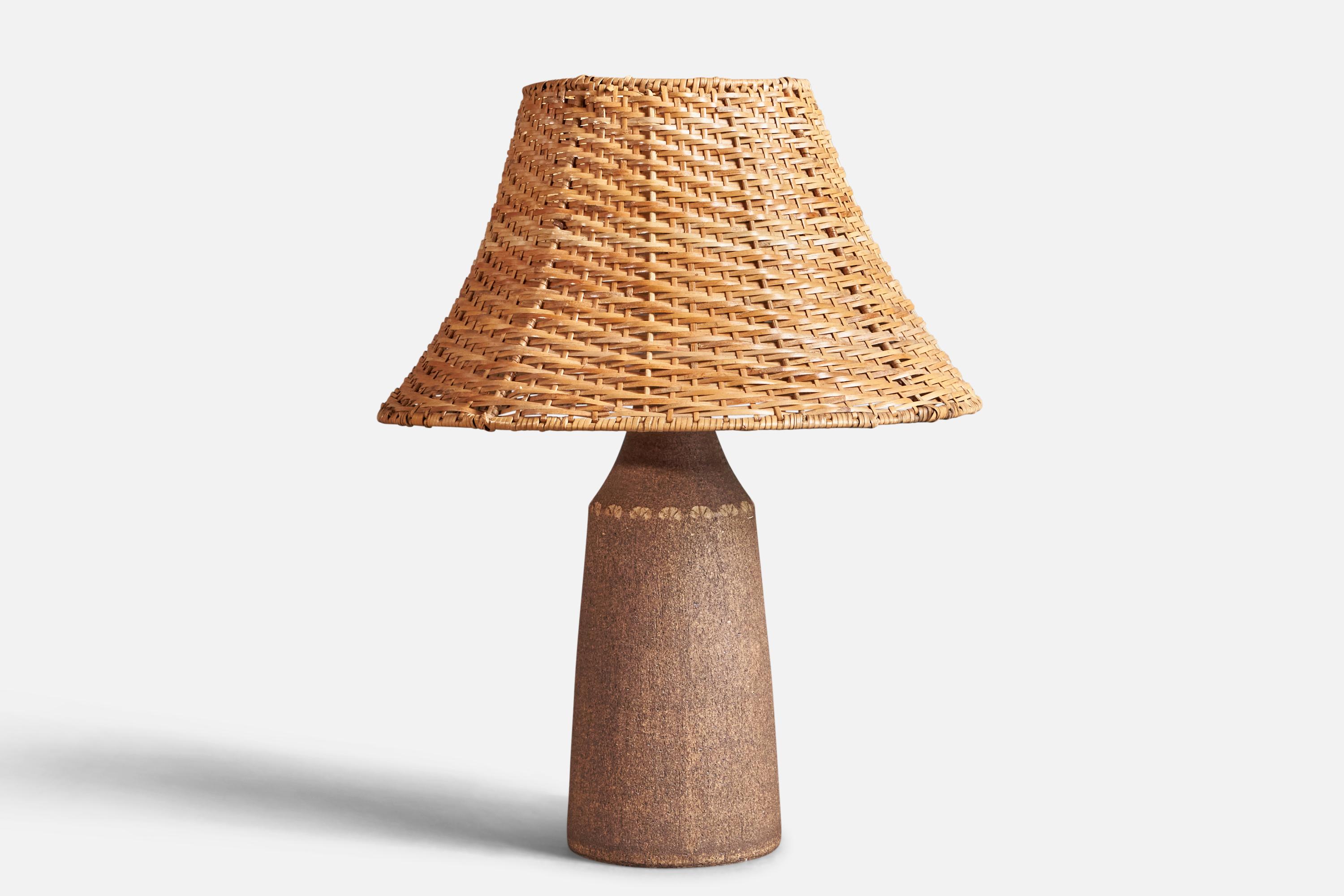 A brown stoneware and rattan table lamp, designed and produced by Nils Allan Johannesson, Barsebäck, Sweden, c. 1960s.

Sold with Lampshade.

Dimensions of Lamp (inches) : (13.75 x 5 x 5)

Dimensions of Shade (inches) : (7 x 14.2  x