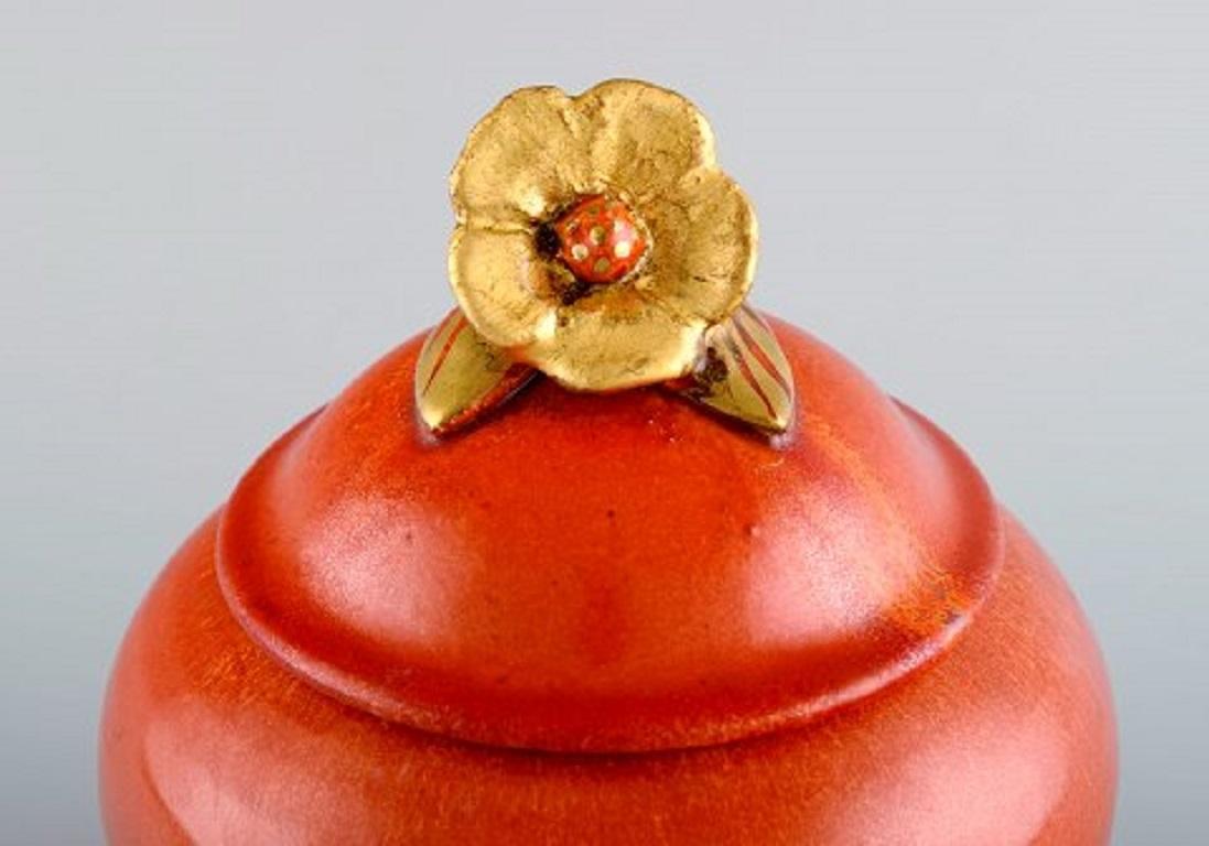 Nils Emil Lundström (1865-1960) for Rörstrand. Antique lidded jar in glazed ceramics. Beautiful orange glaze and flower in gold on the lid, early 20th century.
Measures: 17 x 14 cm.
In excellent condition.
Signed.