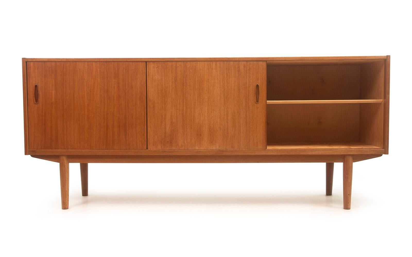 Troeds teak sideboard 

Designed for Hugo Troeds by Nils Jonsson during the 1960s, this stylish sideboard was made in Sweden to a Danish design. Featuring two sliding doors to both the left and right sides, along with four central dovetailed