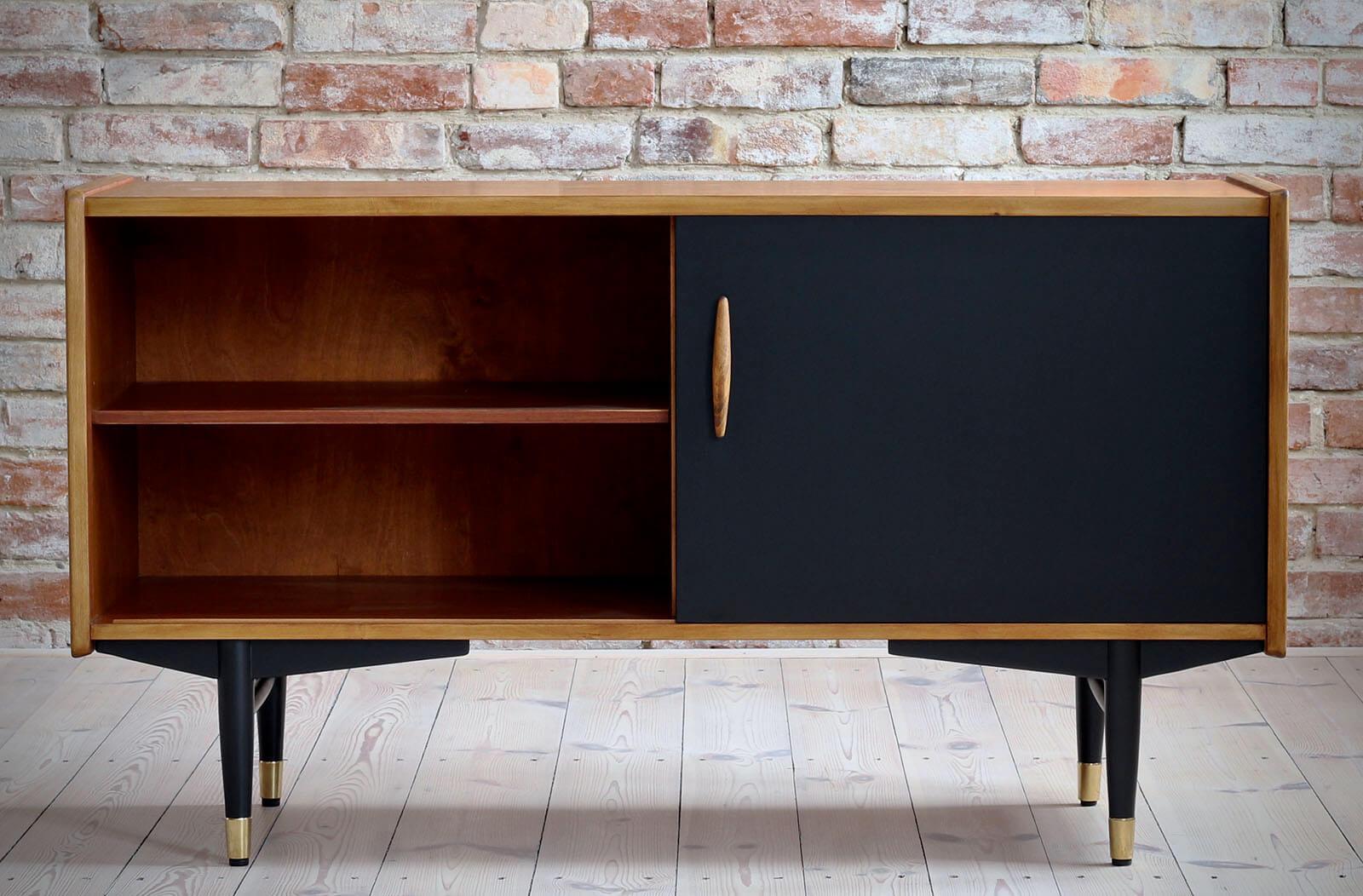 This is not so common model of sideboard by Nils Jonsson in teak wood with black sliding door, a sculpted handle, elegant black base completed with subtle brass legs cups - a great example of Scandinavian Modern style in its best. The piece was