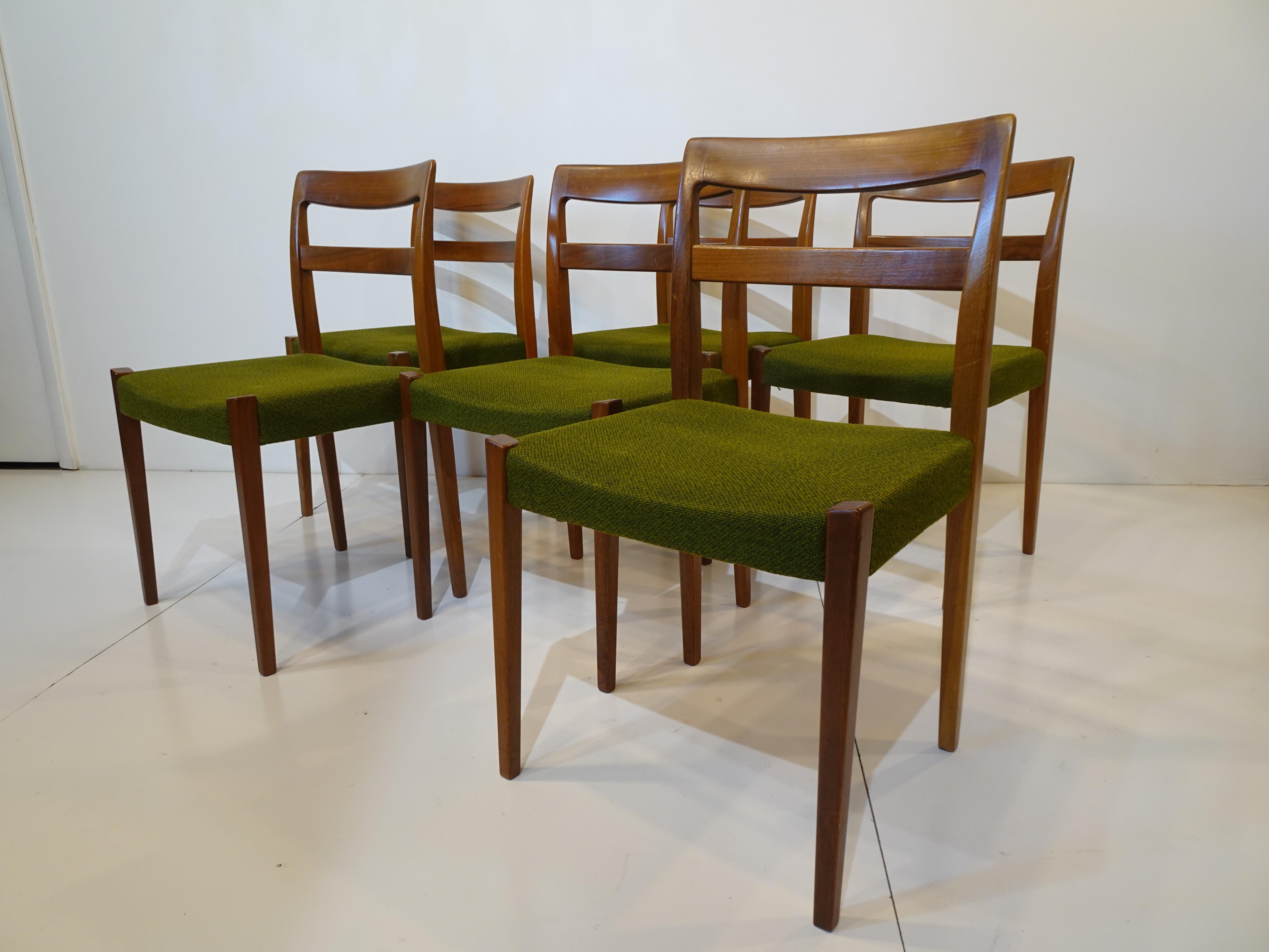 A set of six walnut framed dining chairs with original green woven upholstered seats, a simple design constructed very well for maximum sturdiness and dining comfort. Designed by Nils Jonsson manufactured by Troeds Bjarnum Sweden.