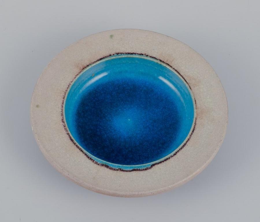 Nils Kähler pour Kähler. Trois bols en céramique. 
Verre de couleur sable et turquoise.
Ca. 1970.
Marqué.
En parfait état avec des craquelures naturelles.
Le plus grand : D 16,0 cm x H 3,0 cm.
Le plus petit : D 10,0 cm x H 2,5 cm.