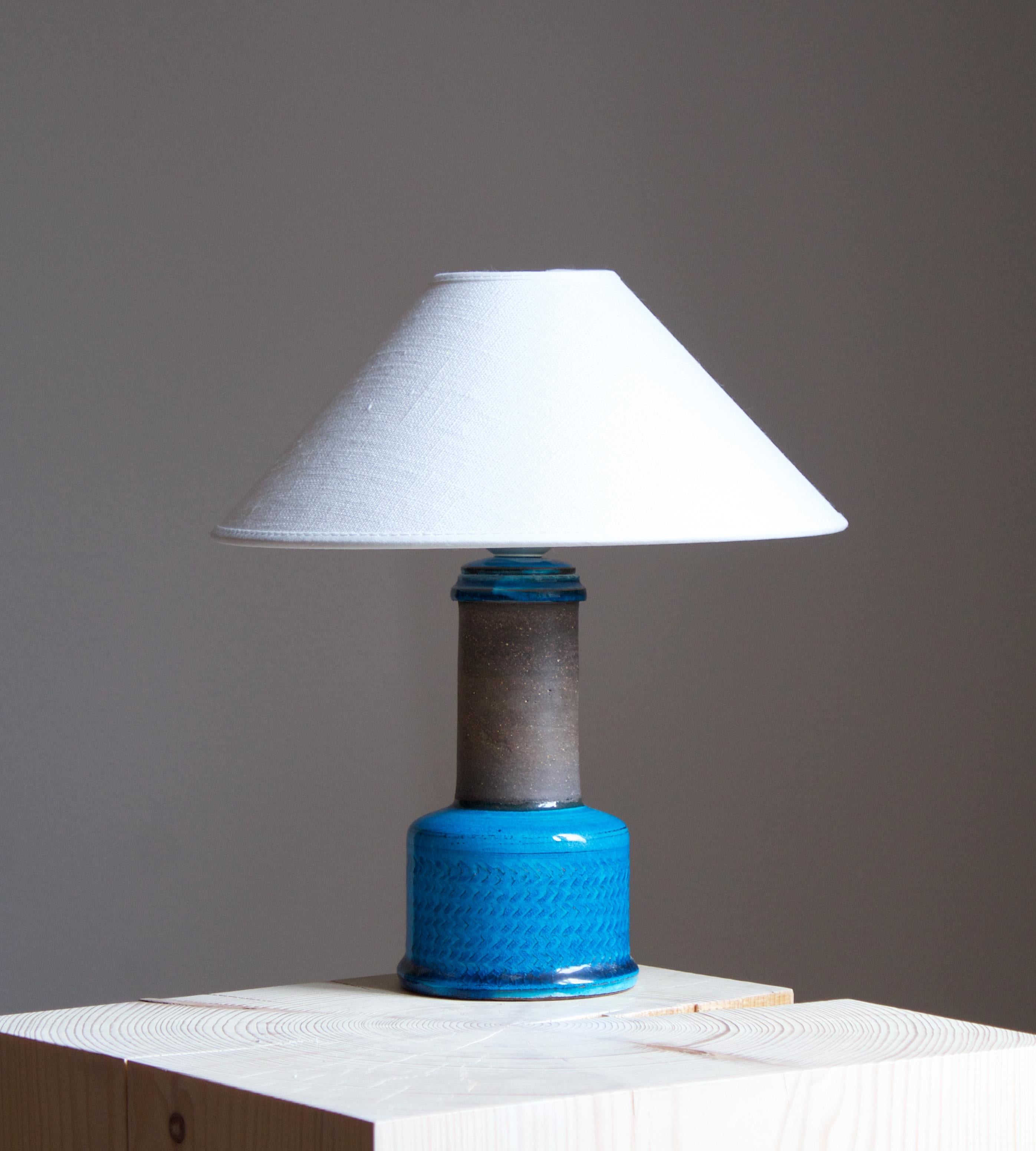 A table lamp designed by Nils Kähler., Denmark, 1950s. In blue glazed stoneware.

Purchase does not include lampshade. Stated dimensions exclude lampshade, height includes socket.

Other designers of the period include Palshus, Axel Salto,