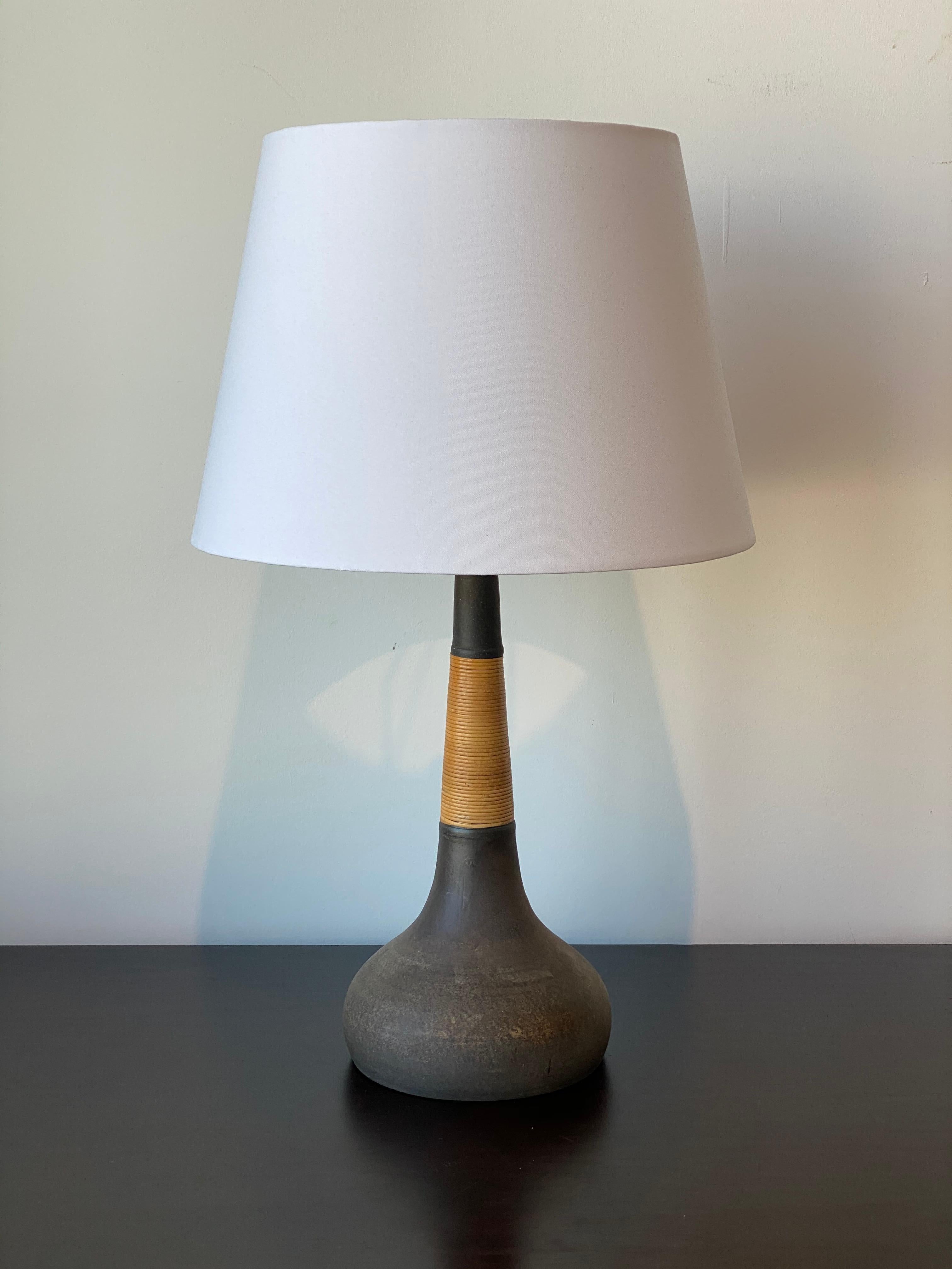 A table lamp designed by Nils Kähler. Produced for Le Klint, Denmark, 1950s. In glazed stoneware and wrapped cane. 

Other designers of the period include Palshus, Axel Salto, Carl-Harry Stålhane, Gunnar Nylund.