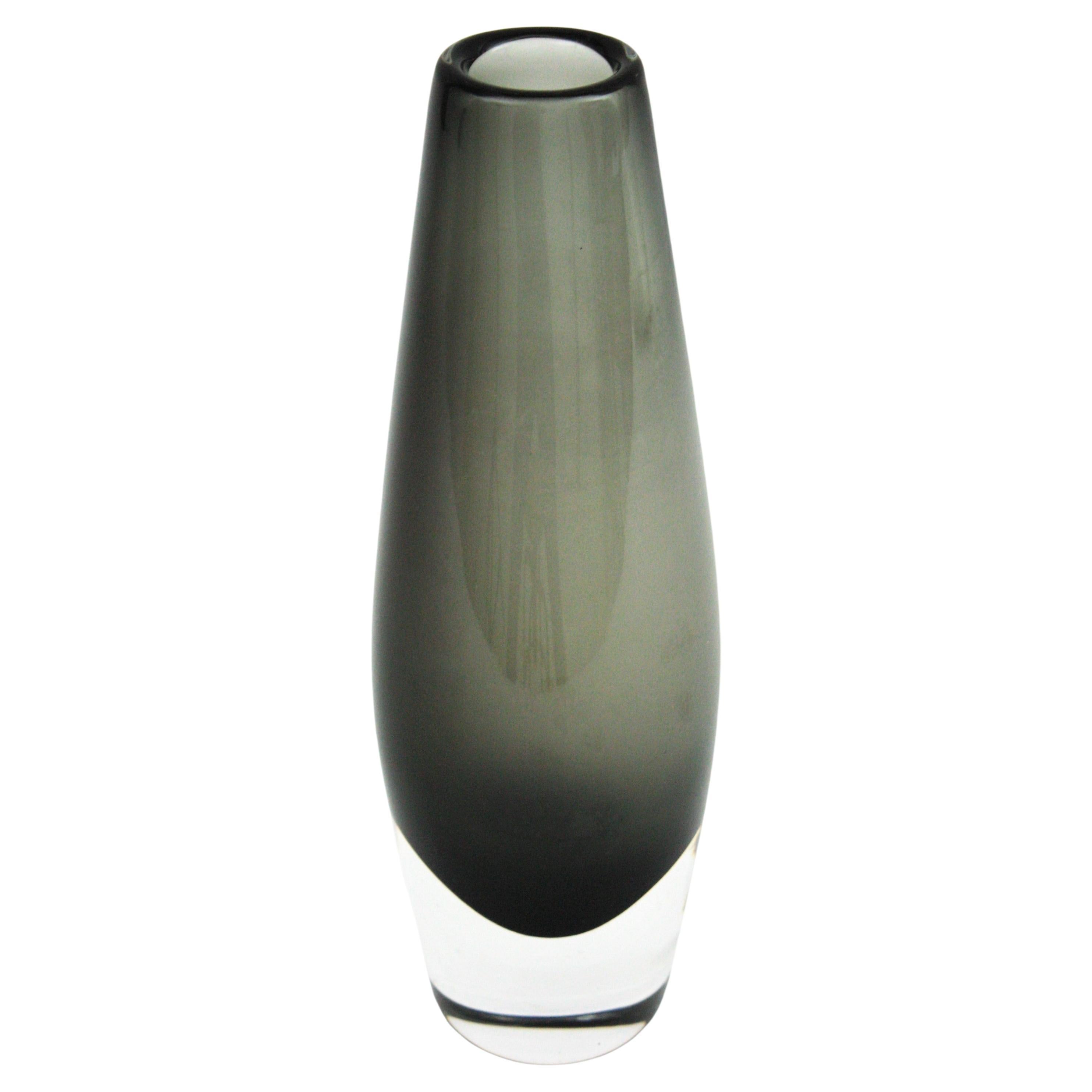 Scandinavian Modern Sommerso Smoked Grey Tall Glass Vase by Nils Landberg for Orrefors

Elegant smoked grey and clear sommerso glass vase. Designed by Nils Landberg and manufactured by Orrefors. Sweden, 1960s
This hand blown glass vase has a