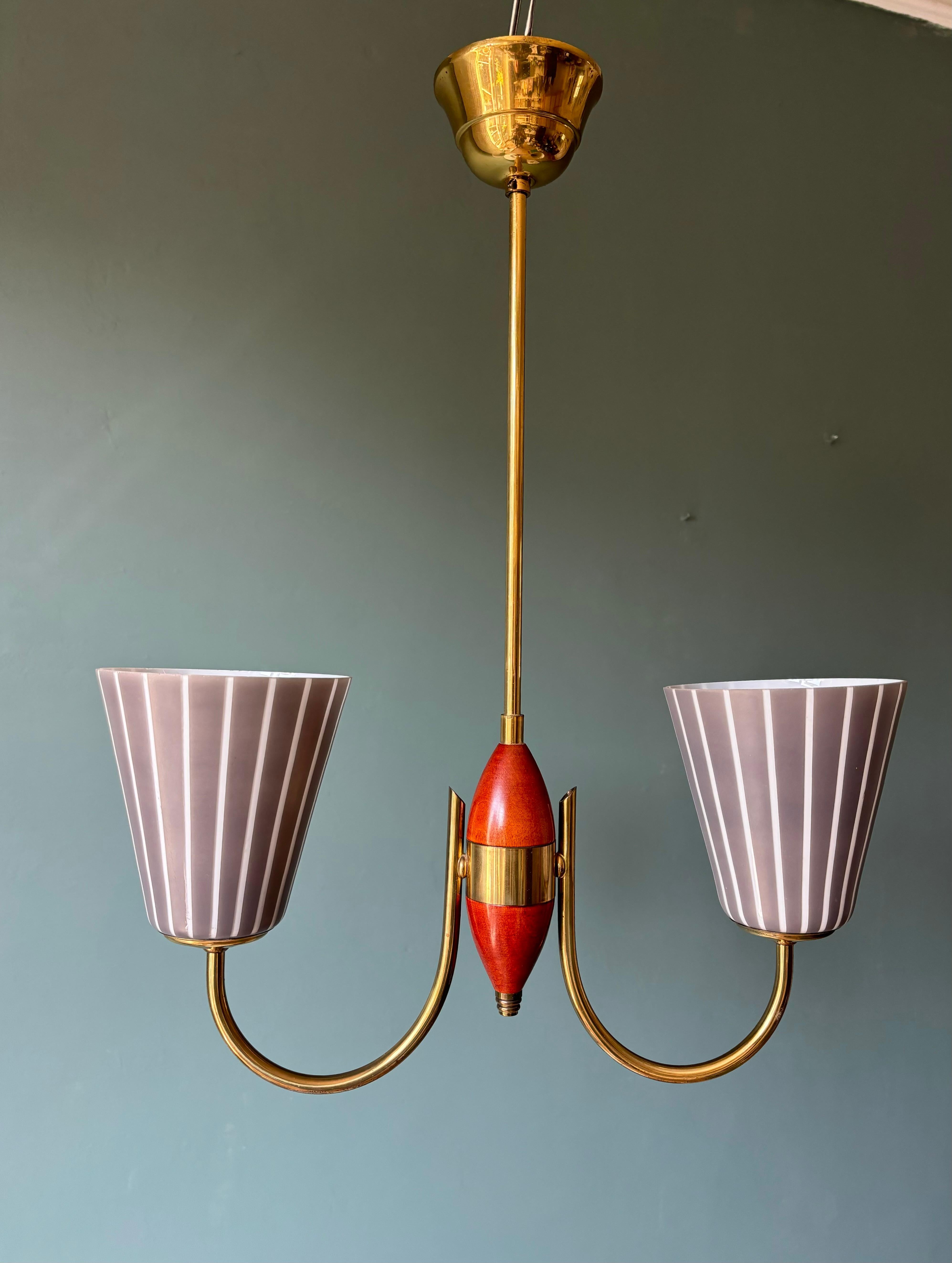 Striking early midcentury two headed striped cone art glass chandelier by Swedish glass company Orrefors. This model is attributed to designer Nils Landberg (1907-1991) who created striped glass shades for Orrefors in the late 1940s. 

This elegant