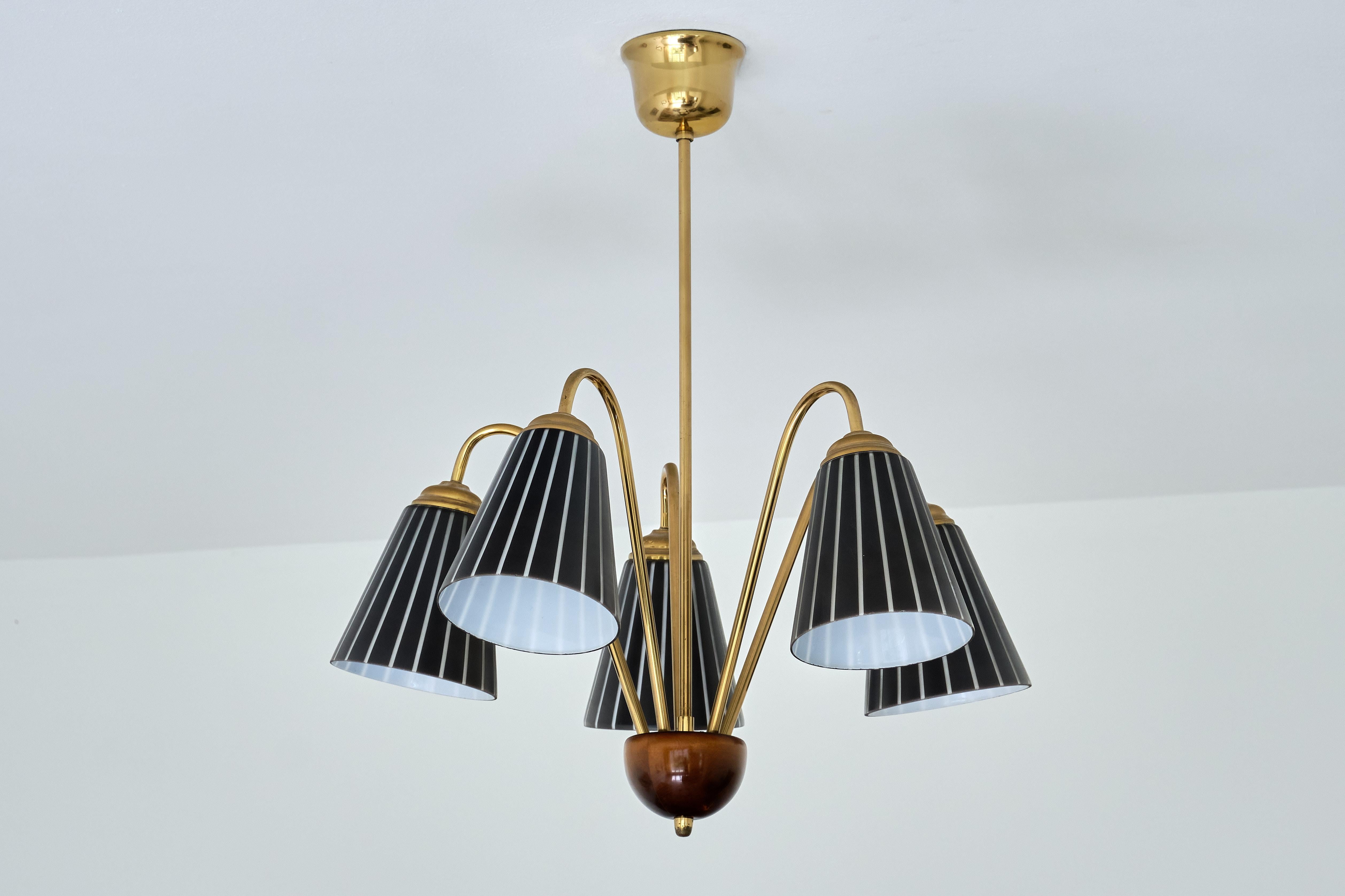 This rare chandelier was produced by the glass company Orrefors in Sweden in the late 1940s. The design is attributed to Nils Landberg, a designer who has created similar striped glass shades for the company.

The striking design consists of a