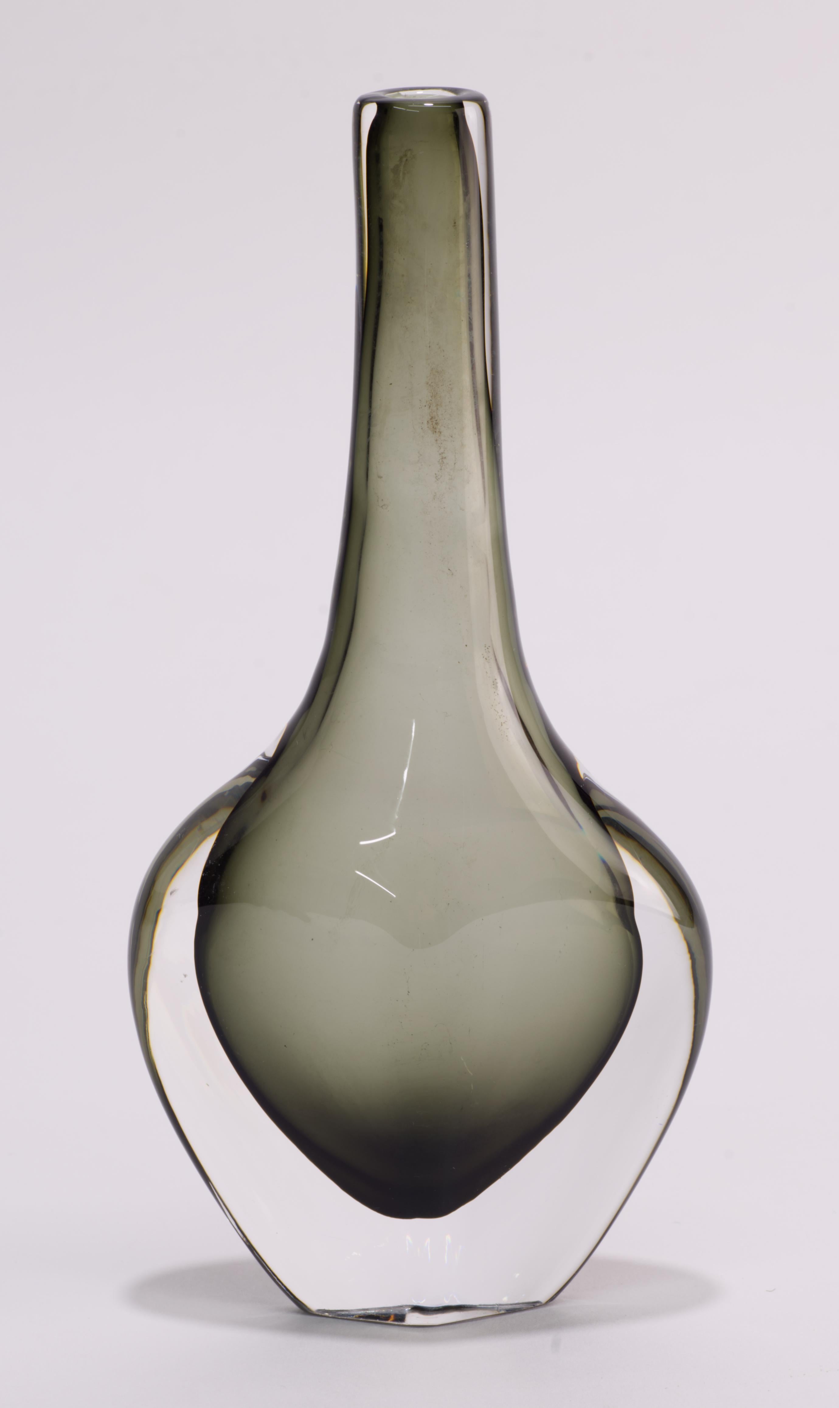  Il vaso sommerso in vetro grigio fumo e trasparente di The Modern Scandinavian è stato disegnato da Nils Landberg per Orrefors Sweden negli anni '50.

Il vaso è chiaramente firmato sul fondo con l'incisione 