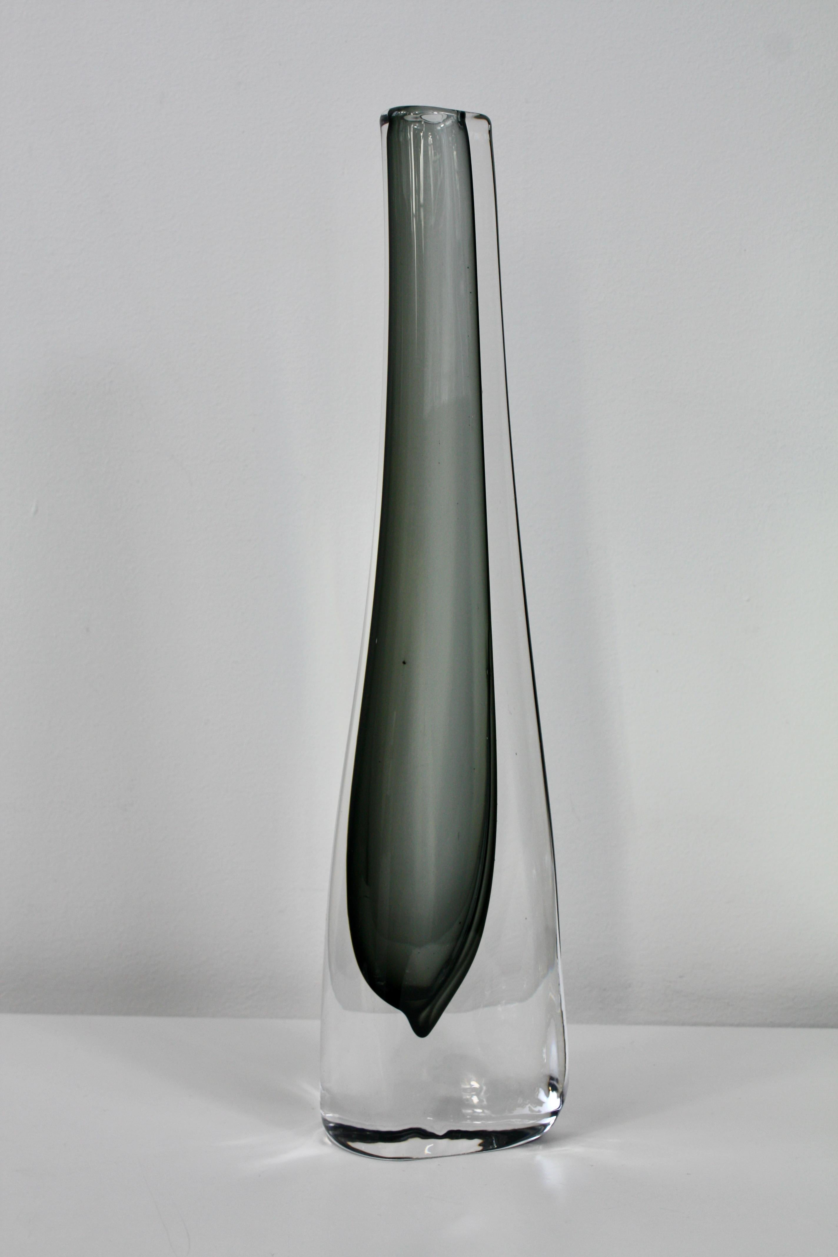 Vaso grigio sommerso di forma triangolare disegnato da Nils Landberg per Orrefors, Svezia.
Questo vaso in vetro alto, elegante e sottile è caratterizzato da vetro trasparente e vetro asimmetrico verde scuro/grigio. 

Il vaso è grande e pesante e