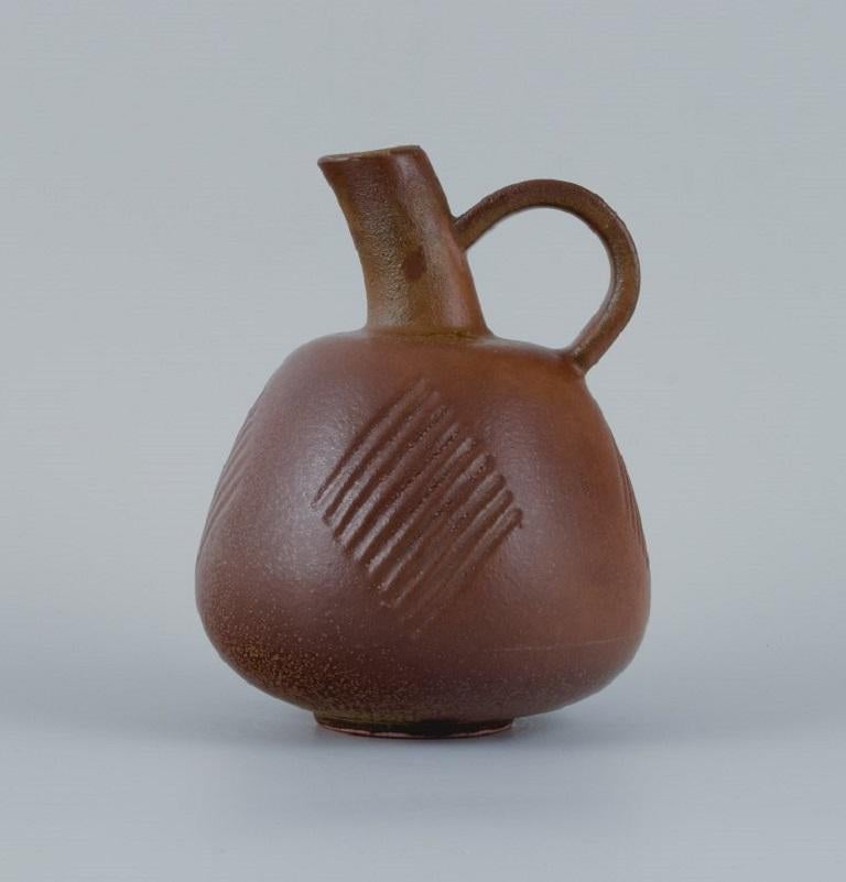 Nils Thorsson (1898-1975) for Royal Copenhagen, stoneware jug with brownish glaze.
Marked.
Fourth factory quality.
Dimensions: H 18.0 x D 13.5 cm.