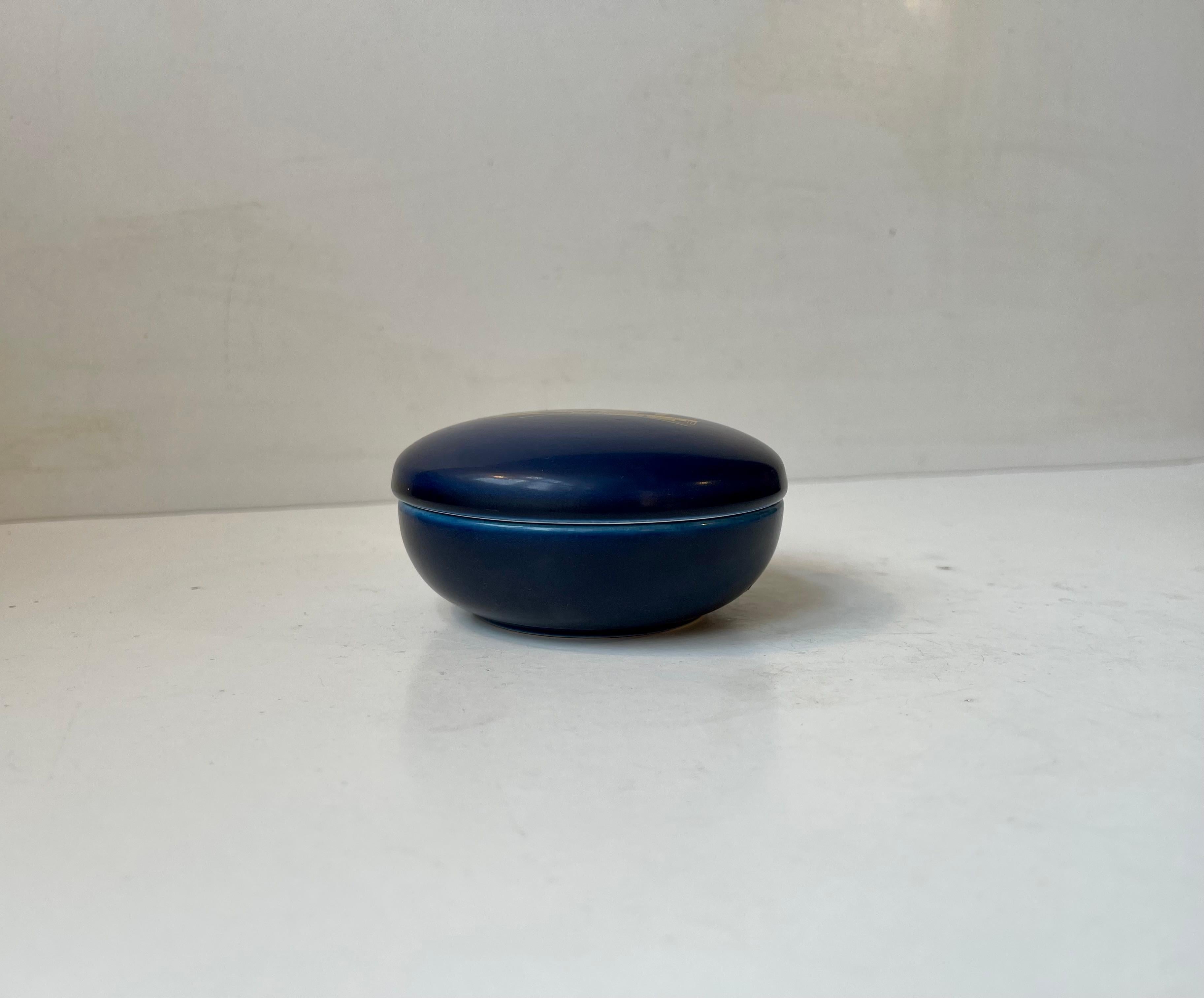 Ceramic Trinket designed by Nils Thorsson and manufactured by Aluminia in Denmark during the 1950s. Decorated in a vibrant blue glaze and featuring a piece of Danish Hospital or School Architecture in gold glaze/foliage. It can be used as a trinket