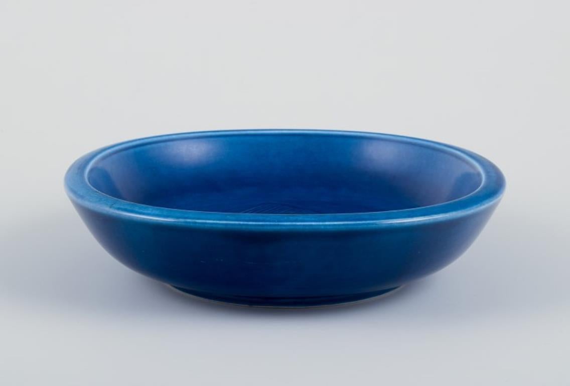 Nils Thorsson per Aluminia. 
Ciotola in faience con finitura smaltata blu. Caratterizzato da un motivo a forma di pesce.
Metà del XX secolo.
Numero di modello 2650.
Contrassegnato.
In perfette condizioni.
Prima qualità di fabbrica.
Dimensioni: D