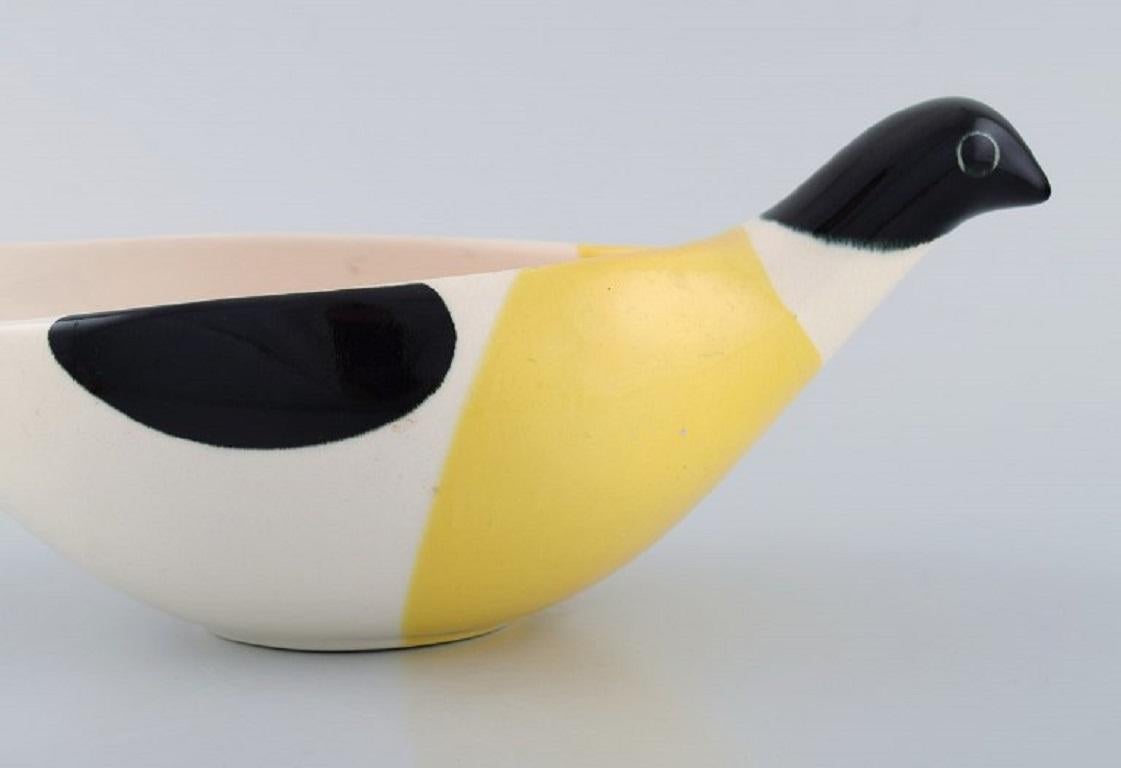 Nils Thorsson für Aluminia. Große Columbine-Schale aus handbemalter glasierter Fayence. 
Weißer, schwarzer und gelber Vogel. Modellnummer 2749. 
Datiert 1958.
Maße: 29 x 10 cm.
In ausgezeichnetem Zustand.
1. Fabrikqualität.