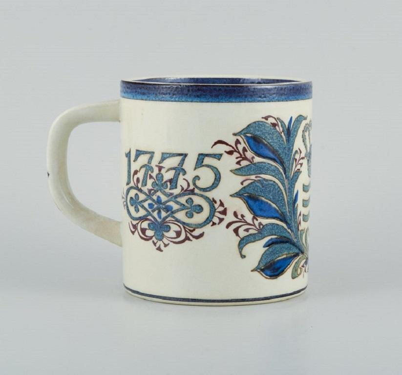 Nils Thorsson for Royal Copenhagen.
Large anniversary mug in earthenware. 1775-1975.
In perfect condition.
First factory quality.
H 14.0 x D 12.5 cm. without a handle.