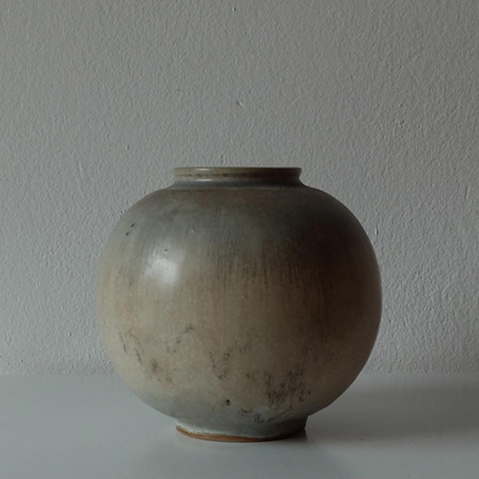 Nils Thorsson for Royal Copenhagen, Glazed ceramic vase, 1940s.

The surfaces of this beautiful spherical vase are covered in a multi-colored glaze with serene and earthy colors, recalling of the astounding Scandinavian's landscapes. Simple yet