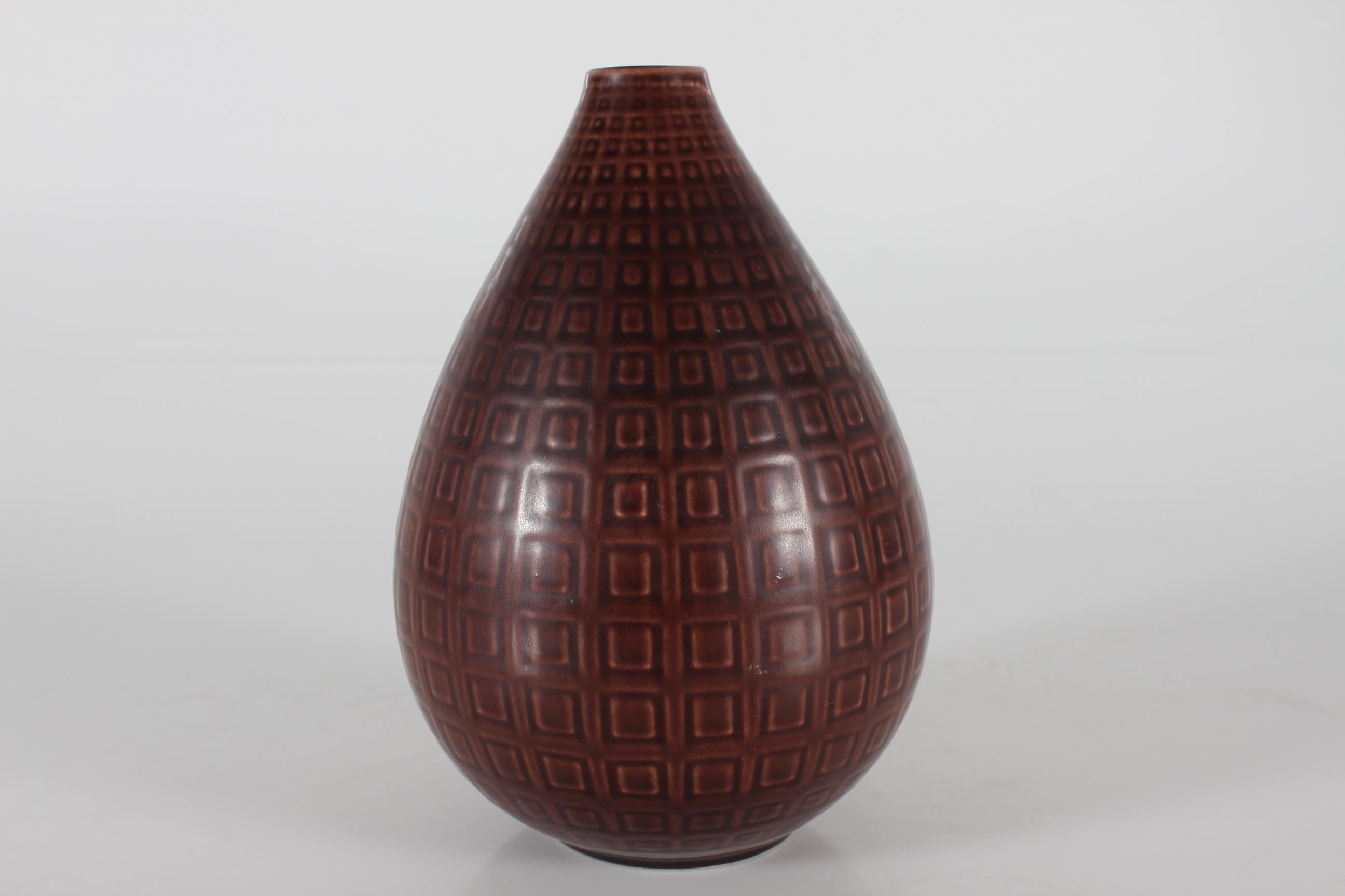 Marselis vase by Nils Thorsson (1898-1975) manufactured by Aluminia later Royal Copenhagen in Copenhagen, Denmark.

The pear-shaped faience vase features a maroon brown glaze over a design of small squares The surface is tactile.

Nils Thorsson