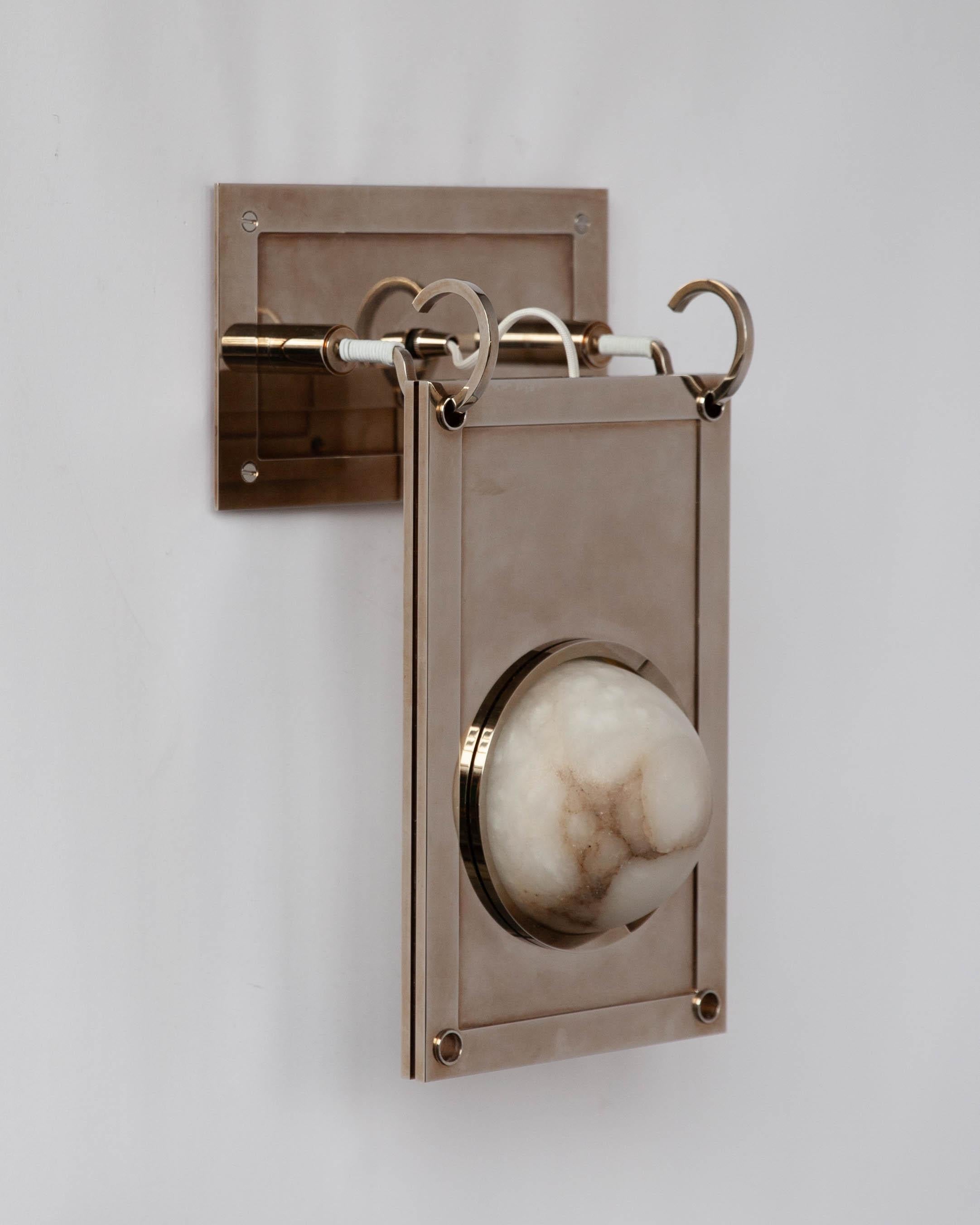 MWL4510 
A wall sconce made of a hand-carved, veined white alabaster globe lens, set in a solid slab of machined brass with threaded porthole bezels. The stone is illuminated by integrated warm-dim LED lamping and the body hangs from leather-wrapped