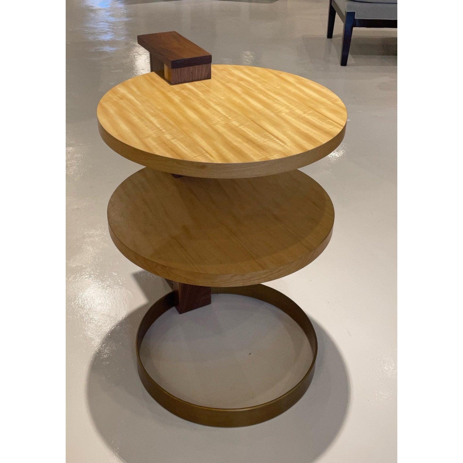Showroom new - The Nina is an eye catcher. Two cantilevered shelves of Beeswing Primavera fit perfectly into the solid Walnut spine of this art deco inspired side table. Nina is grounded by a solid metal, antique brass ring, with a perpendicular