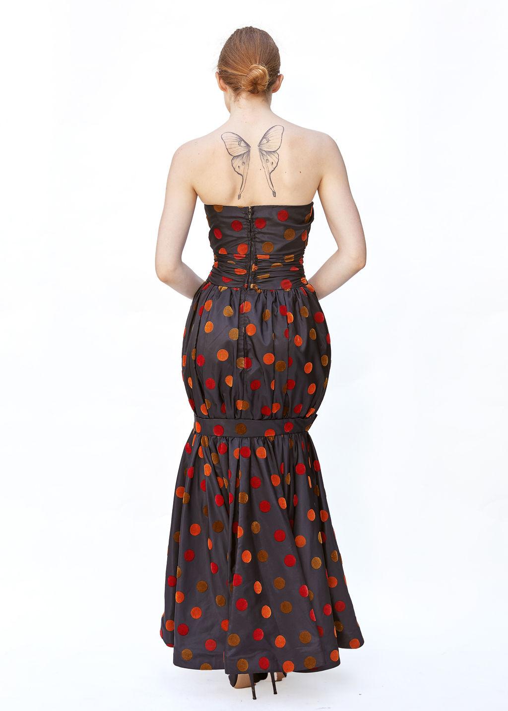 This Nina Ricci Multicolor Polka Dot Strapless Balloon Gown is a captivating vintage piece, exuding playful elegance and couture craftsmanship. Designed with a striking strapless silhouette, this gown features an eye-catching array of multicolored