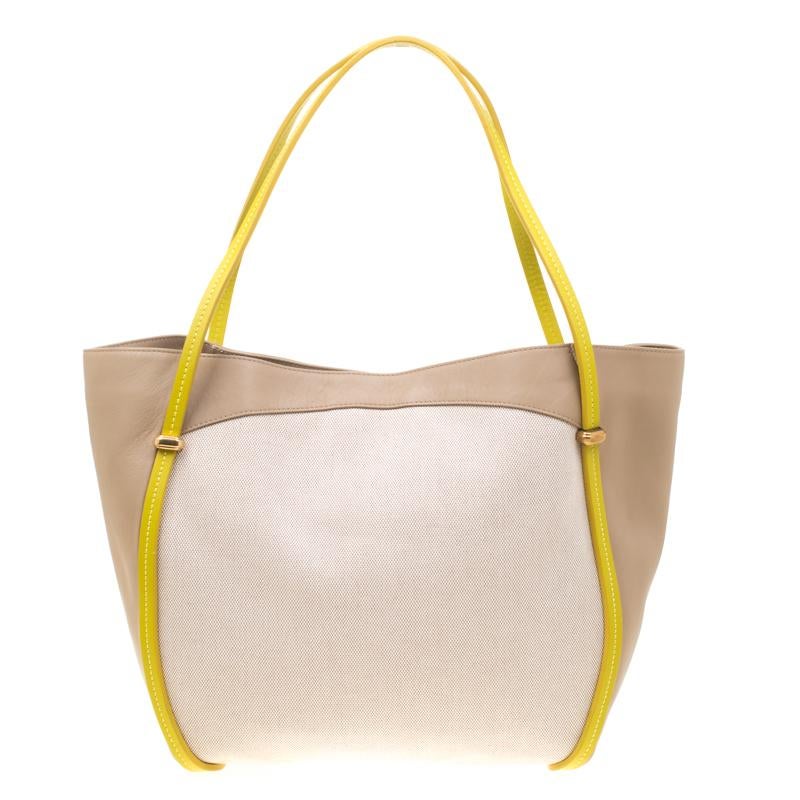 One cannot go wrong with a piece like this Nina Ricci bag. Let your audience be dazzled when you make your own style statement with this fashionable and delicate leather and canvas creation. Its neat suede lined interior ensures a simple look. Look