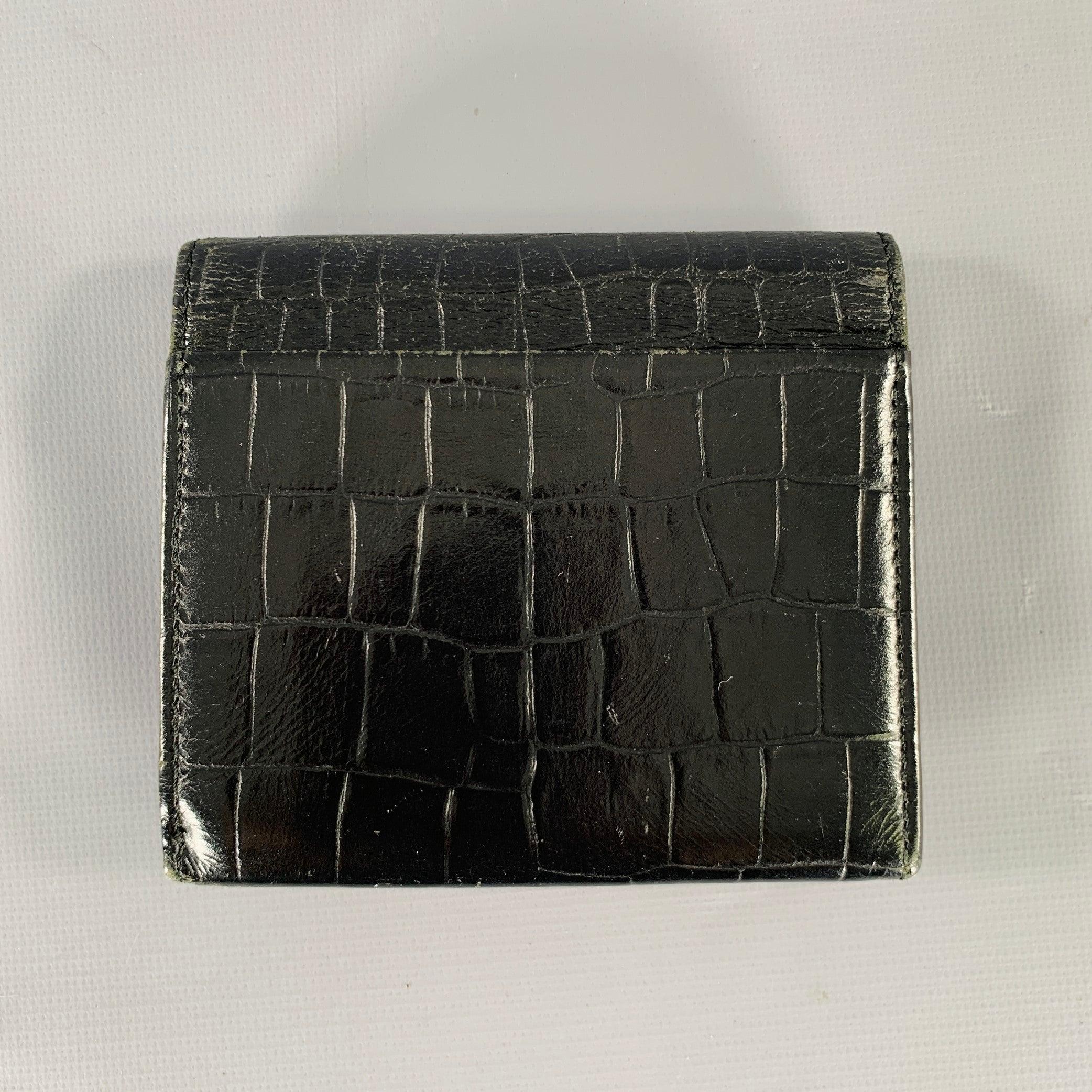 Cartera NINA RICCI
en piel negra con relieve de cocodrilo, con un estilo bifold con compartimento expansible para monedas. 

Medidas: 
  Longitud: 4 pulgadas Altura: 3,5 pulgadas 
  
  
 
Referencia Sui Generis: 132658
Categoría: Bolsos y artículos