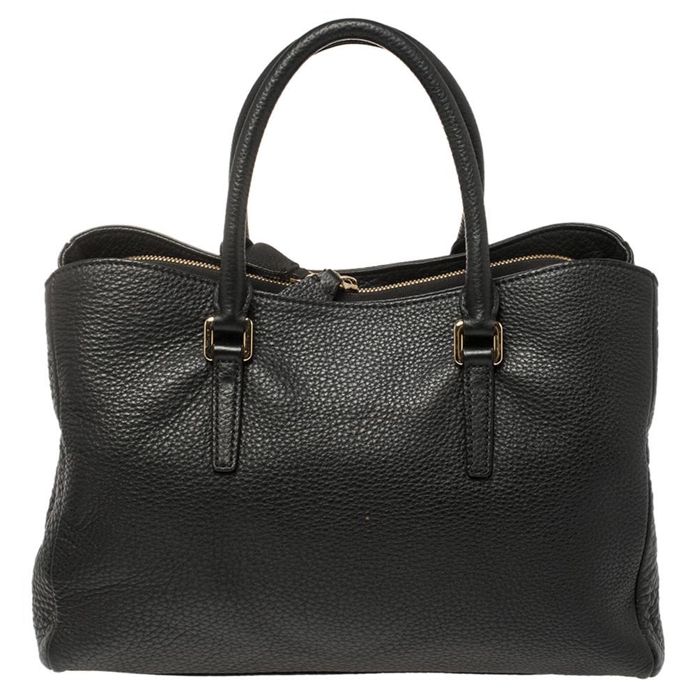 Functional, versatile, and stylish, this must-have tote comes from the house o Nina Ricci. It has been crafted from quality leather and comes in a classic shade of black. They have dual handles, shoulder strap, gold-tone hardware and logo detailing.