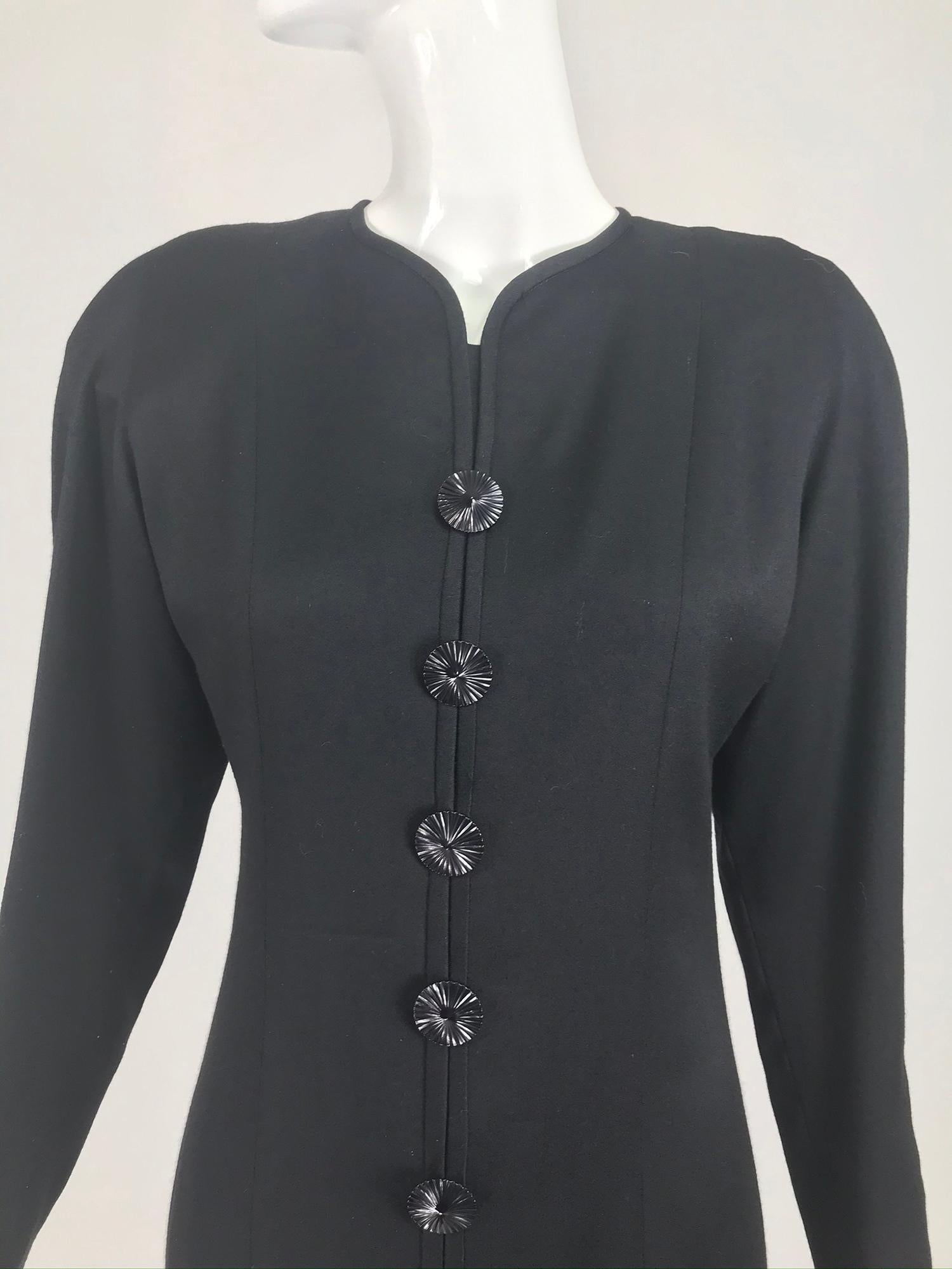 Nina Ricci semi fitted black lightweight wool flannel dress with flared hem from the 1980s. This beautiful dress has long sleeves with button detail cuffs, the dress front has non working button detail, set in decorative top stitched ourtline seams