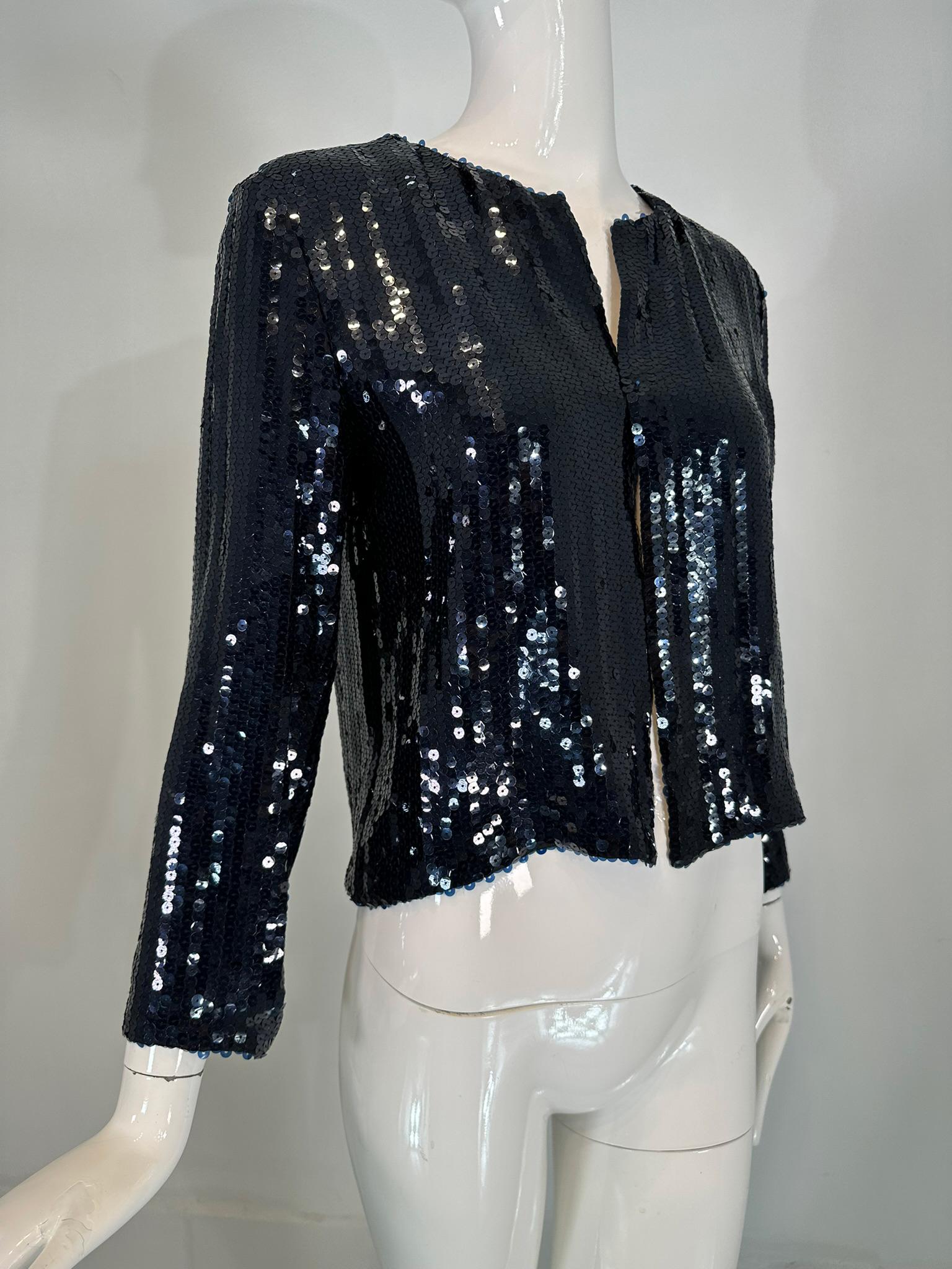Nina Ricci blue sequin open front evening jacket, unworn with tags. Original price $2790. 
Beautiful dark blue jacket is lined in navy silk. Simple & elegant the perfect cover up for any bare evening dress or top. Long straight sleeves, jewel neck.
