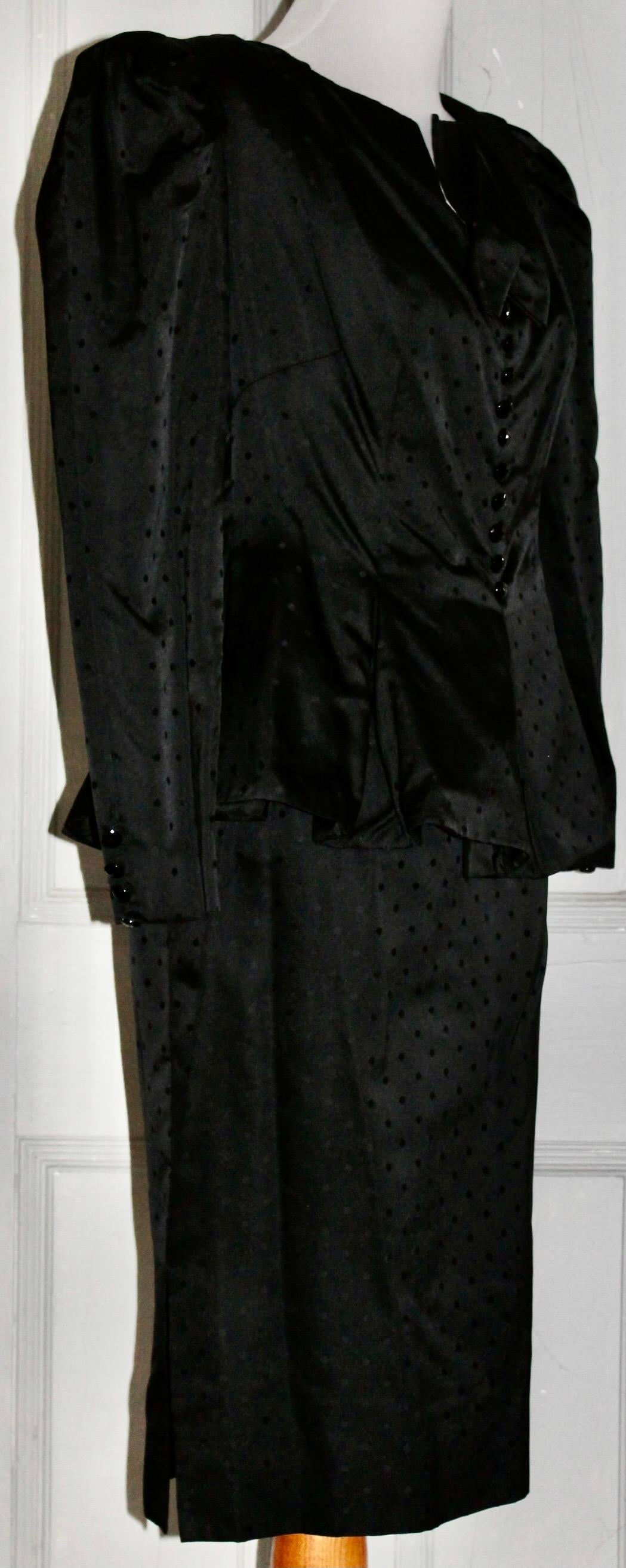 Offering a Nina Ricci 'Boutique' Paris, Black silk suit retailed by Bergdorf Goodman.
Puffy shoulders, skirted waist jacket, black on black polka dots, silk lining, approx. size Eu 38-40. Length of skirt 25.50