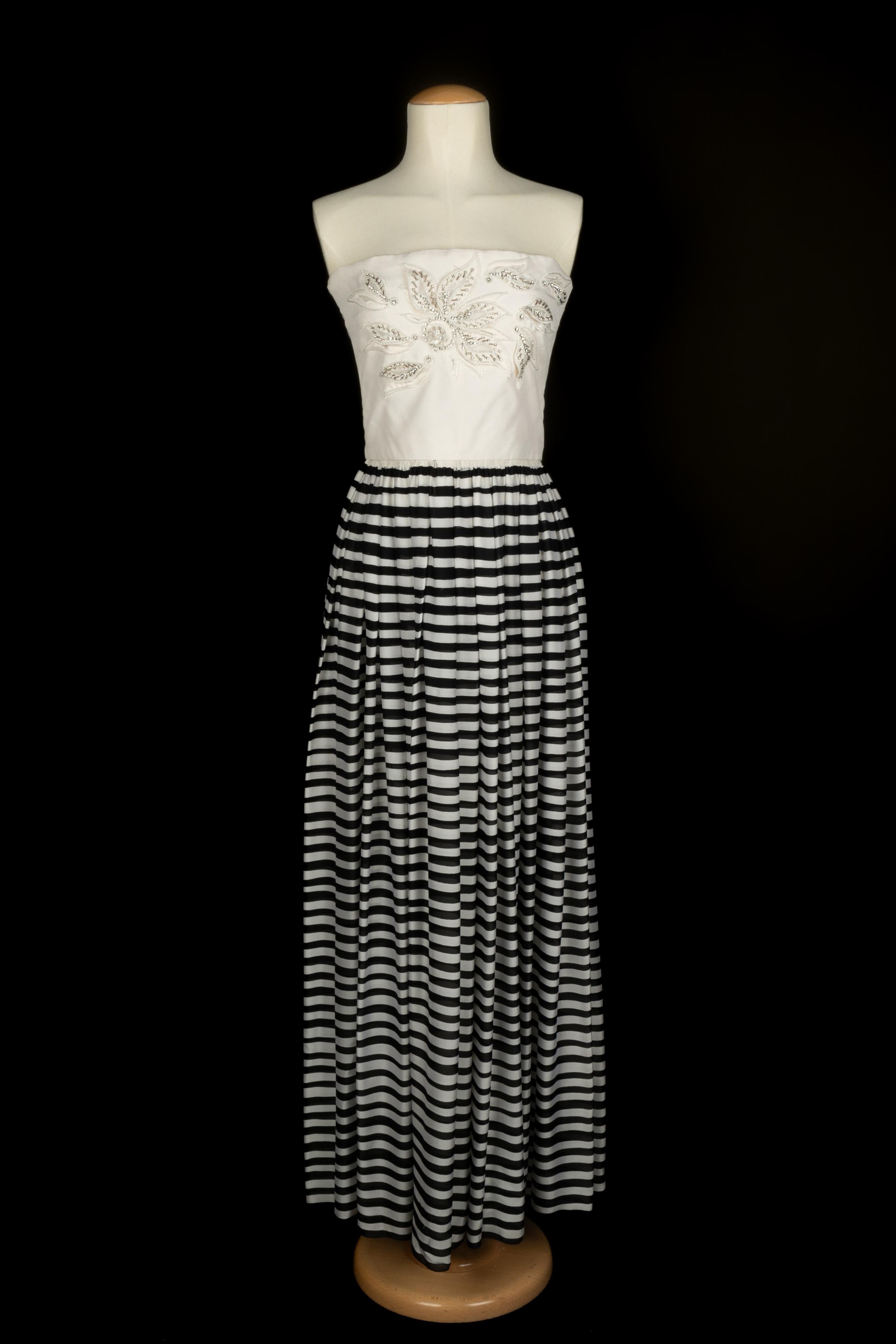 Nina Ricci - (Made in France) Abito bustier in mussola e seta selvatica con petto ricamato con perle e strass. Mancano le etichette della composizione e della taglia, ma veste una 36FR.

Condizioni:
Ottime condizioni

Dimensioni:
Petto: 40 cm -