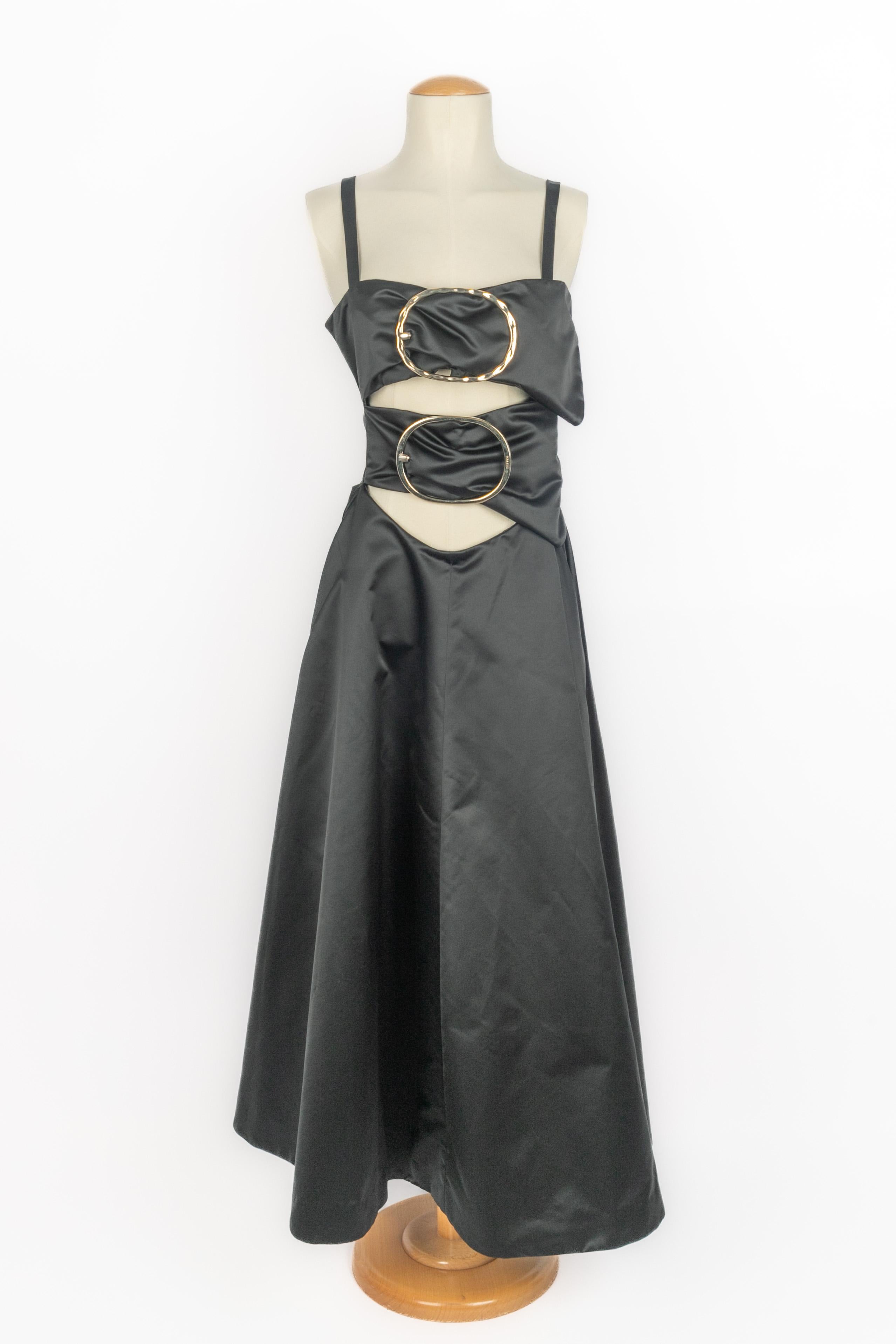 NINA Ricci - (Made in France) Abito in raso nero con collo traforato che ricorda le fibbie della cintura XXL in metallo dorato. Taglia 38FR indicata. Collezione Autunno-Inverno 2018 sotto la direzione artistica di Guillaume