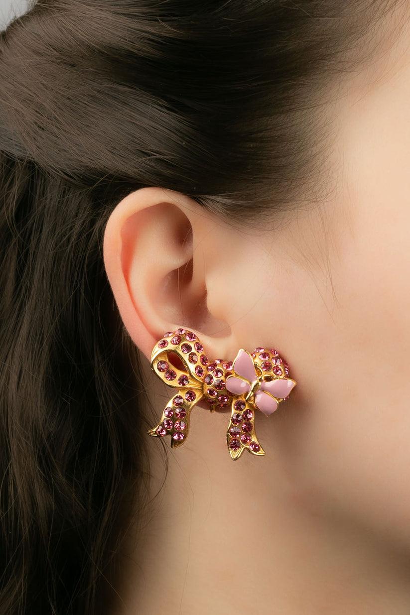 Nina Ricci -Earrings featuring a golden metal bow paved with pink rhinestones.

Additional information:
Dimensions: 4 W x 3 H cm
Condition: Very good condition
Seller Ref number: BO32