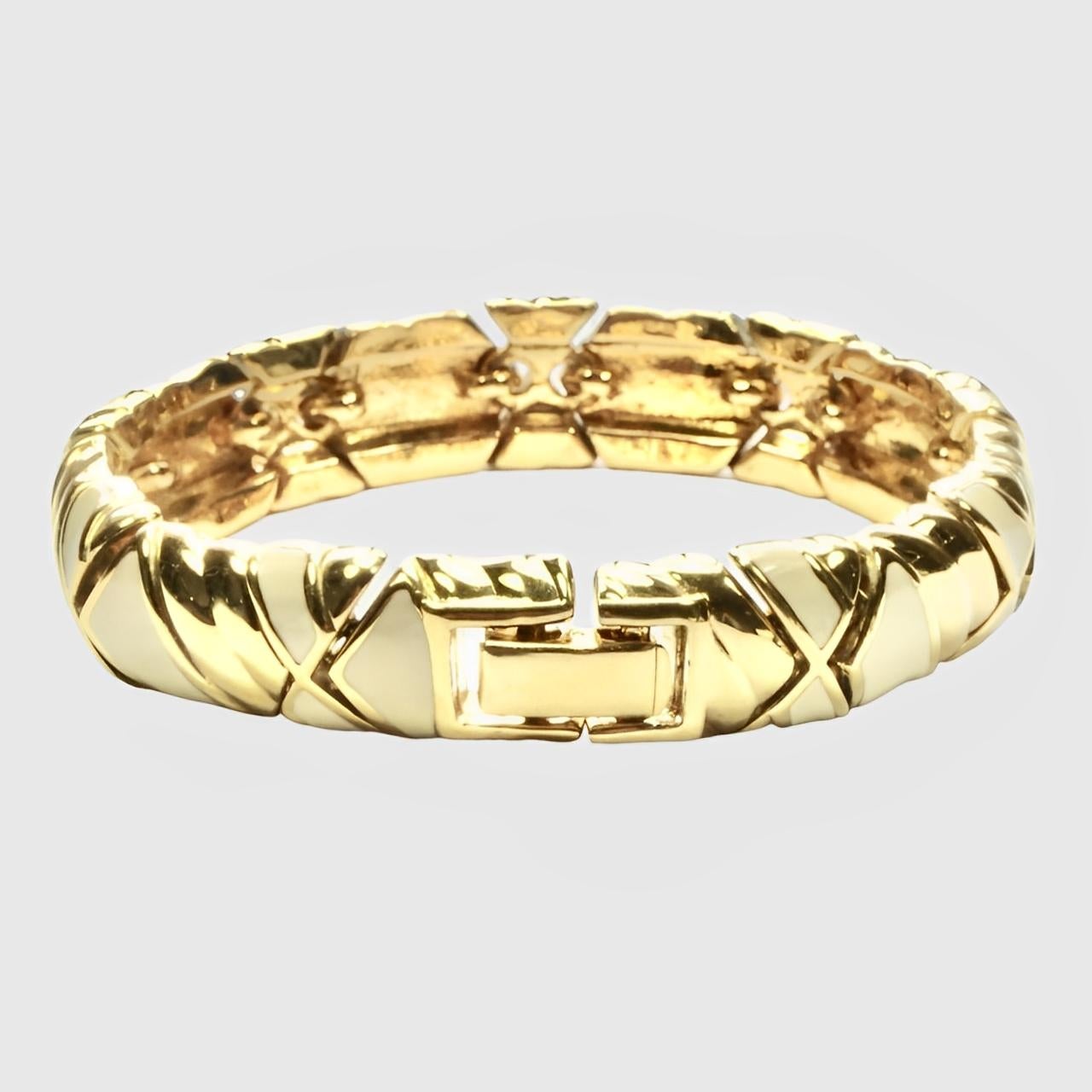 Wonderful Nina Ricci gold plated and cream enamel link bracelet in an abstract design. There is some wear to the gold plating. The reverse of the clasp has an indentation.

Measuring length 19 cm / 7.48 inches by width 1.2 cm / .47 inch.

This is a