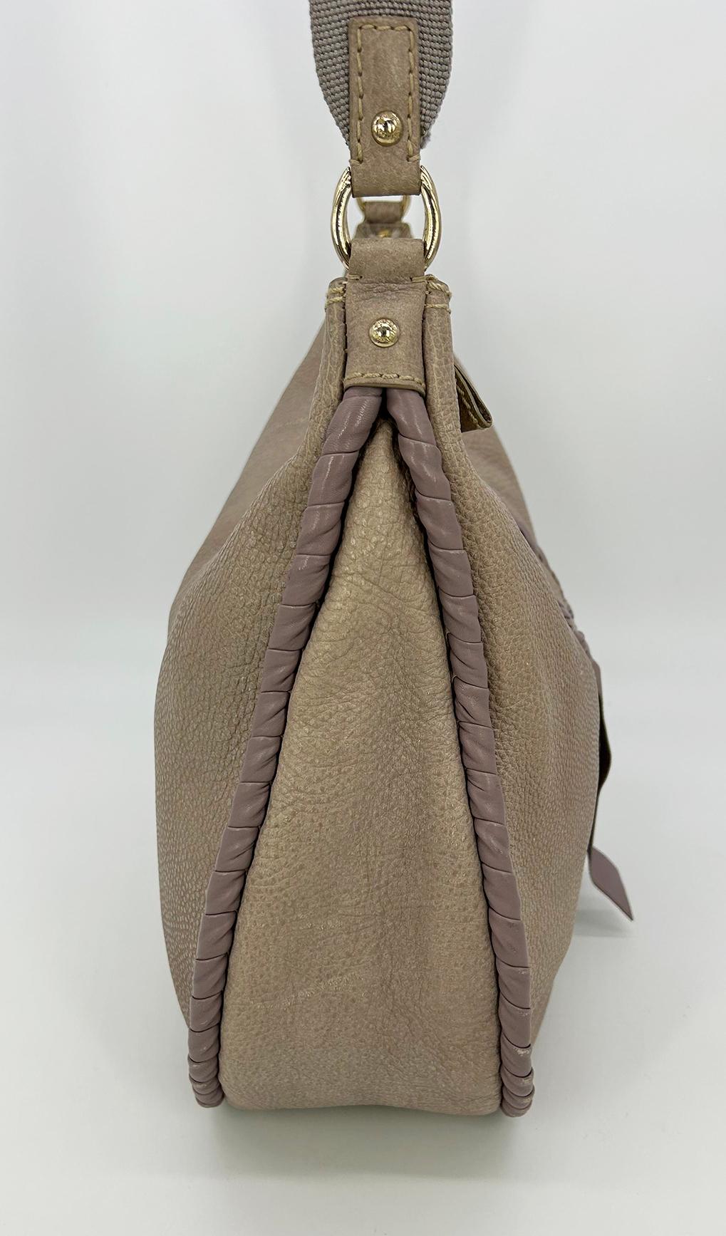Nina Ricci Gray Leather Hobo Shoulder Bag in good condition. Gray pebbled leather body trimmed with taupe leather wrapped edges and a front horseshoe wrapped embroidered bow design. Top zipper closure opens to a tan canvas lined interior with ample