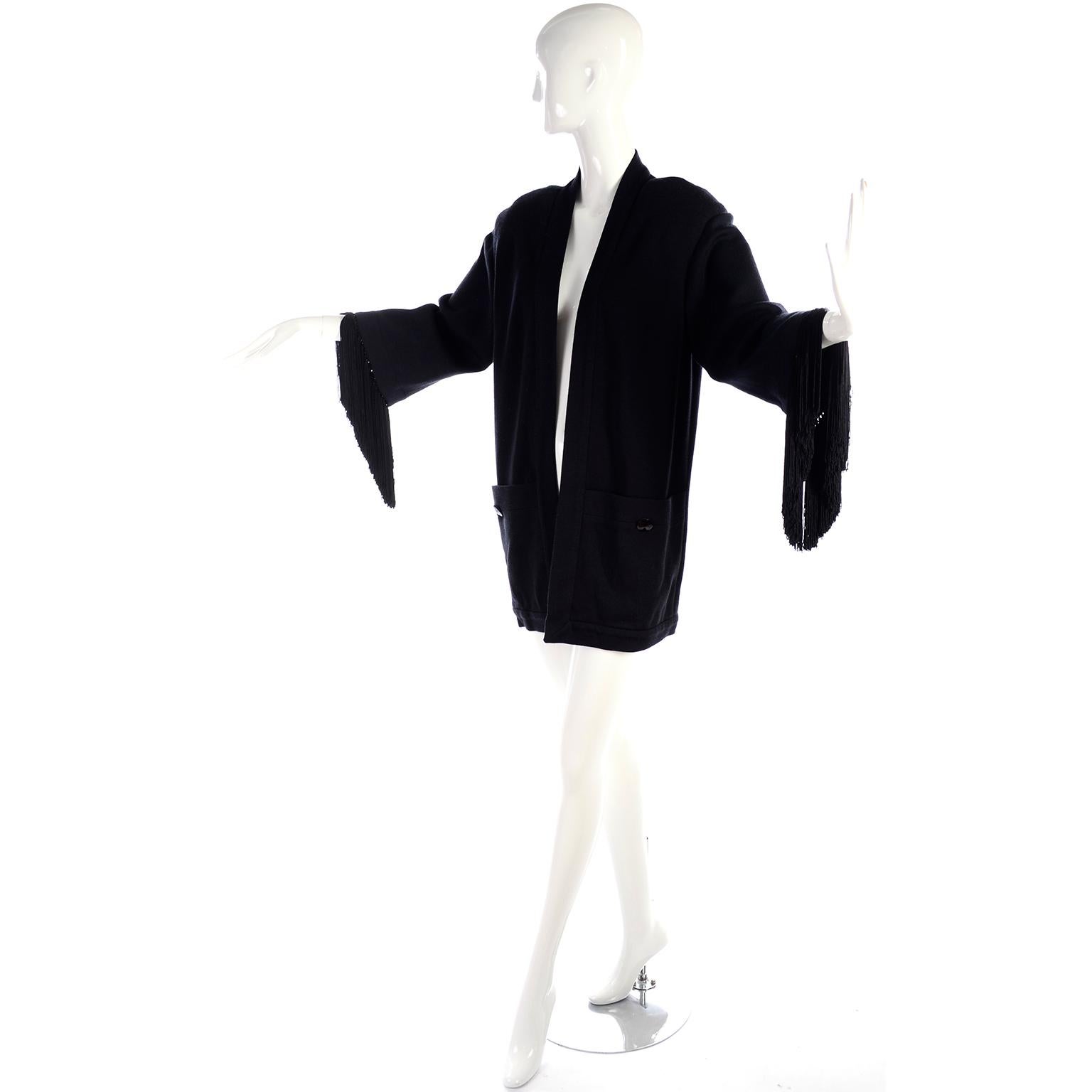 Nina Ricci Haute Boutique Black Wool Open front cardigan style jacket with fringed cuffs. There are shoulder pads (can be removed), front pockets with faceted black glass buttons and the jacket was made in France.  A beautiful piece that is