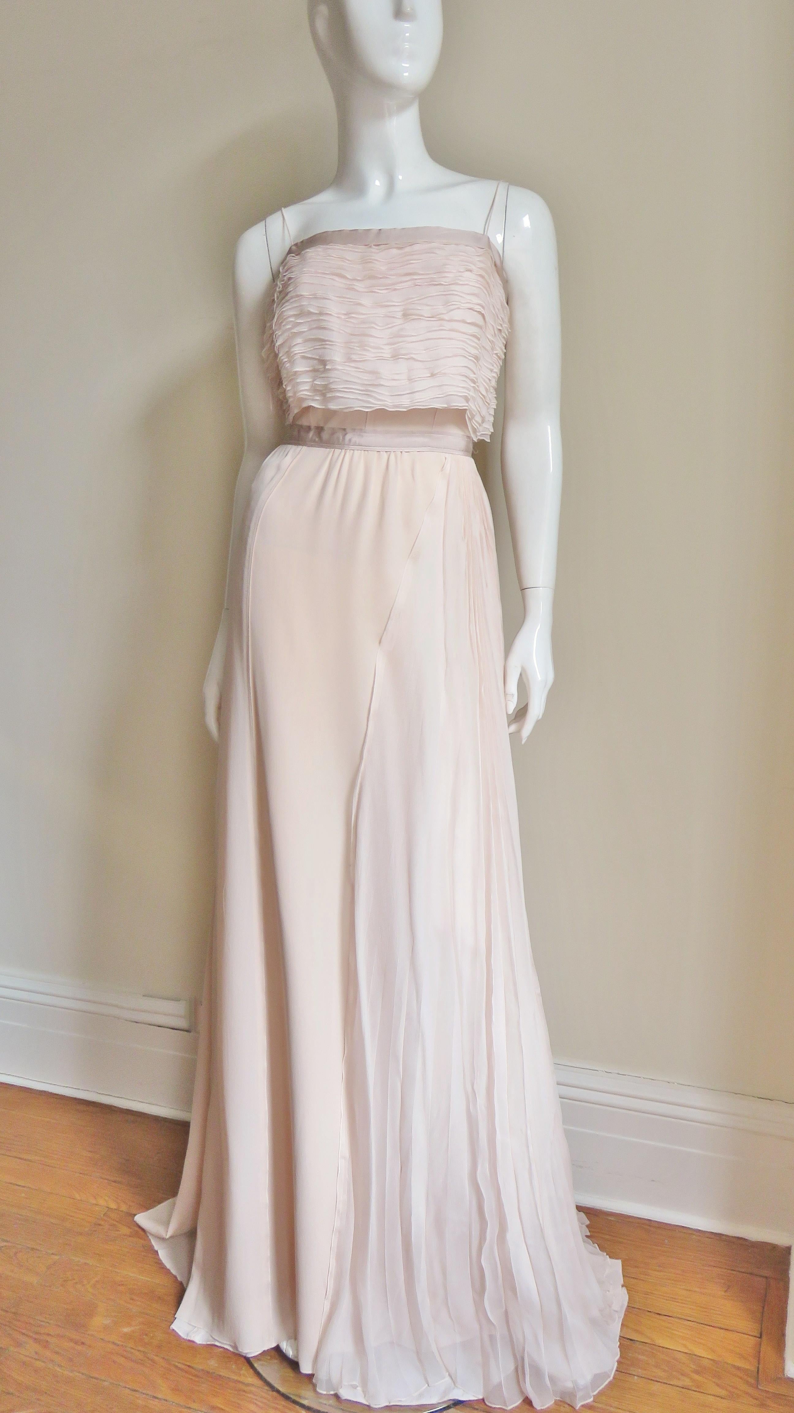A exquisite delicate blush pink silk chiffon and silk crepe gown from Nina Ricci.  The bodice has spaghetti straps and layer upon layer of individually finished horizontal rows of silk chiffon. There is matching silk grosgrain around the the top of