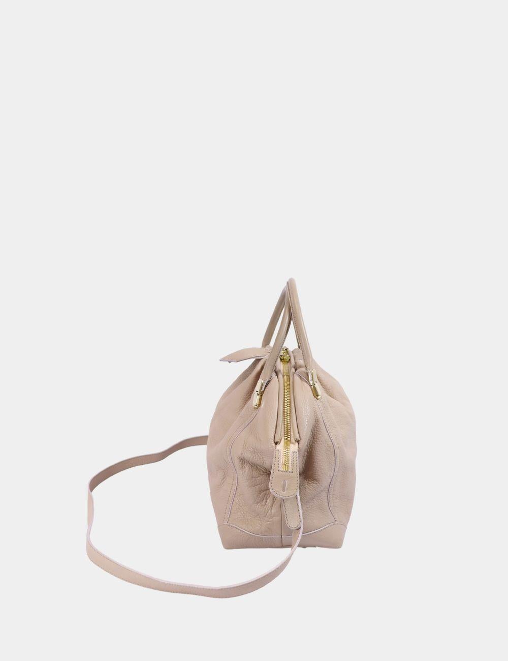 Elevate your everyday style with this elegant Nina Ricci taupe leather handbag. Crafted from supple, textured leather, this versatile bag features a softly structured silhouette with gentle gathers, adding a sophisticated yet relaxed touch. Dual top