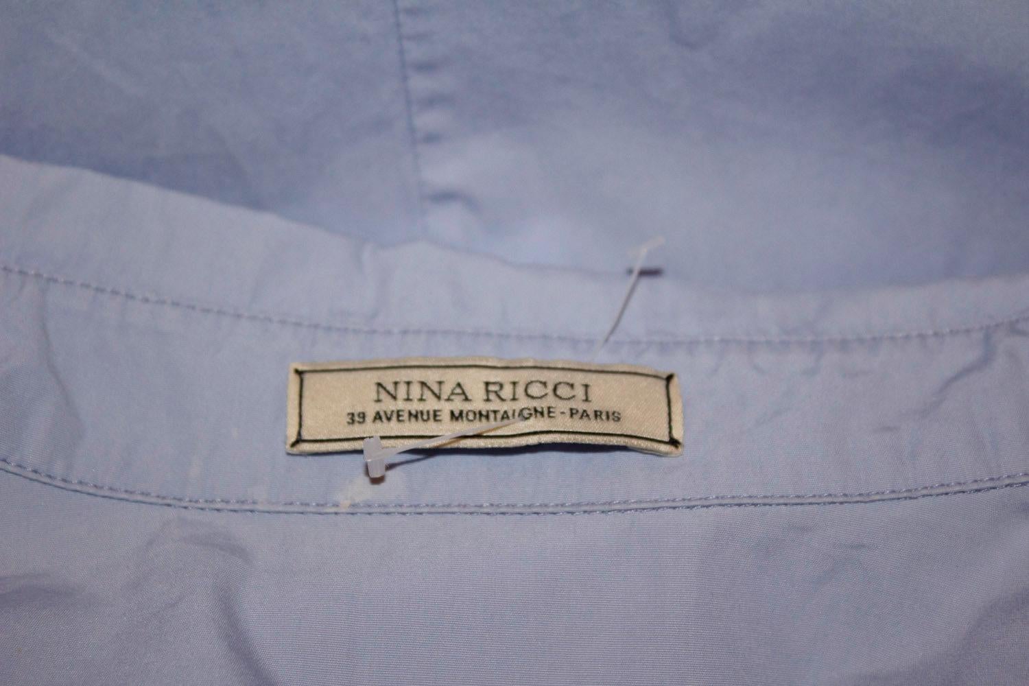 Hübsches und leicht zu tragendes blaues Hemdblusenkleid aus Baumwolle von Nina Ricci Paris. Das Kleid hat ellenbogenlange Ärmel, attraktive Details auf der Vorderseite, seitliche Reißverschlussöffnung und einen 10 '' Schlitz am Rücken. Es ist