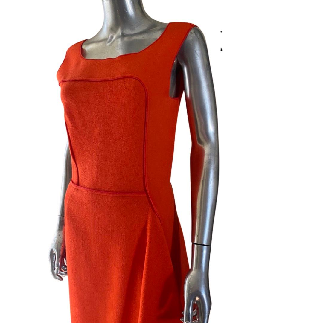 This very chic Nina Ricci dress was purchased at the Ricci boutique in Paris. It is beautiful shade of tangerine orange made of wool crepe with silk trim. Made in France. France: size 40. US; size 8. The amazing part of this modern sheath dress is