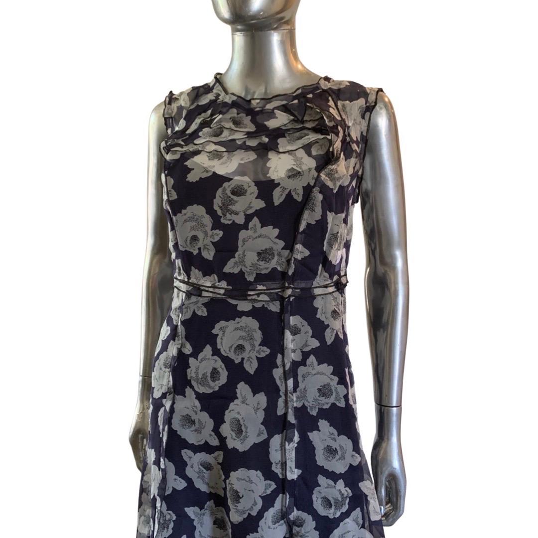 This beautiful Nina Ricci dress is 2 pcs. A silk sheer floral print in greys over navy and a solid dark navy silk slip. It is made so beautifully and designed so interesting in it's modernity. Delicate ruffle on neckline and small ruffle waistline.