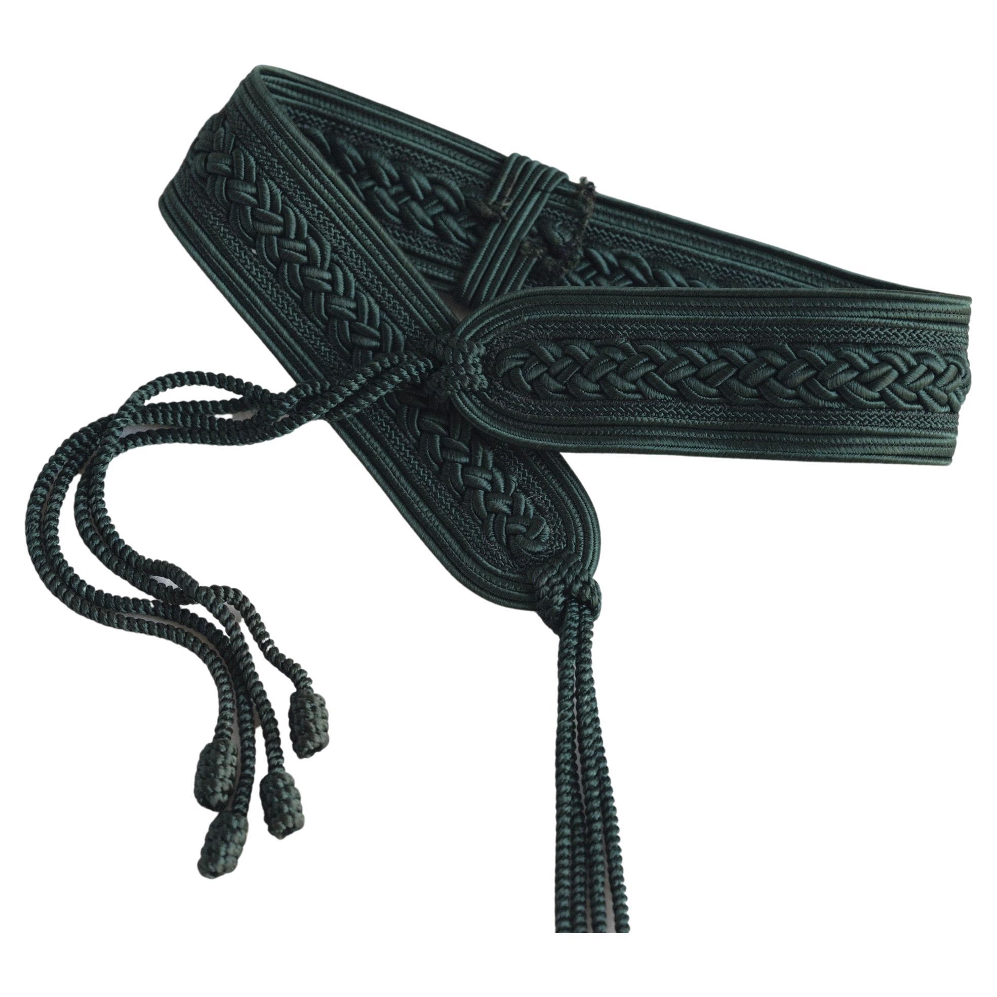 Nina Ricci Passamenterie Belt with Tassels 
Deep green
Four tassels at tie closure
Braided detail 
Circa 1980's or 1990's 
Total Length: 52 inches
Width: 2.25 inches
Waist Size closed at smallest: 27 inches
Open sizing beyond 27 inch waist
Tassel